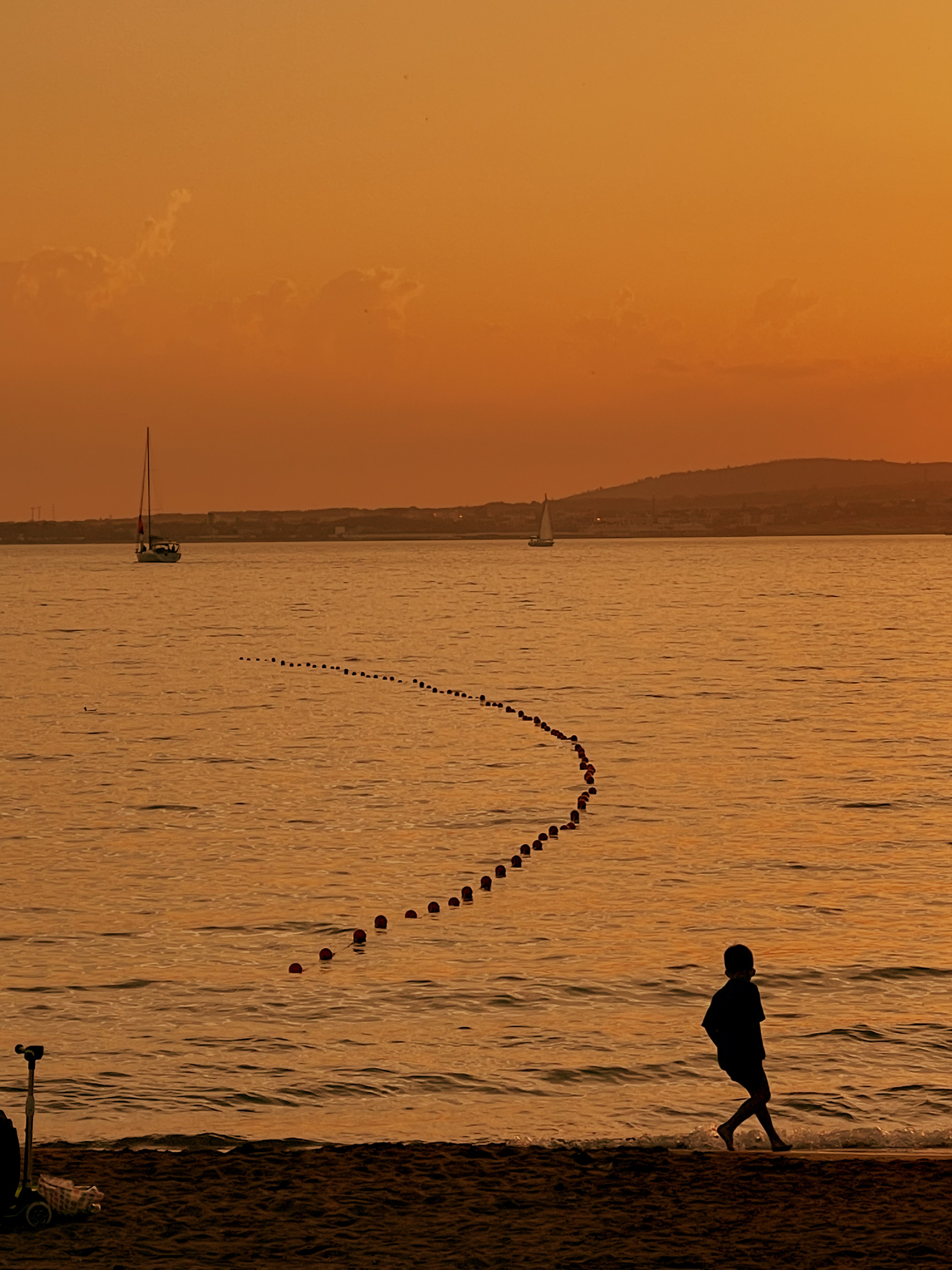 Закатный снимок на берегу моря с ребенком 