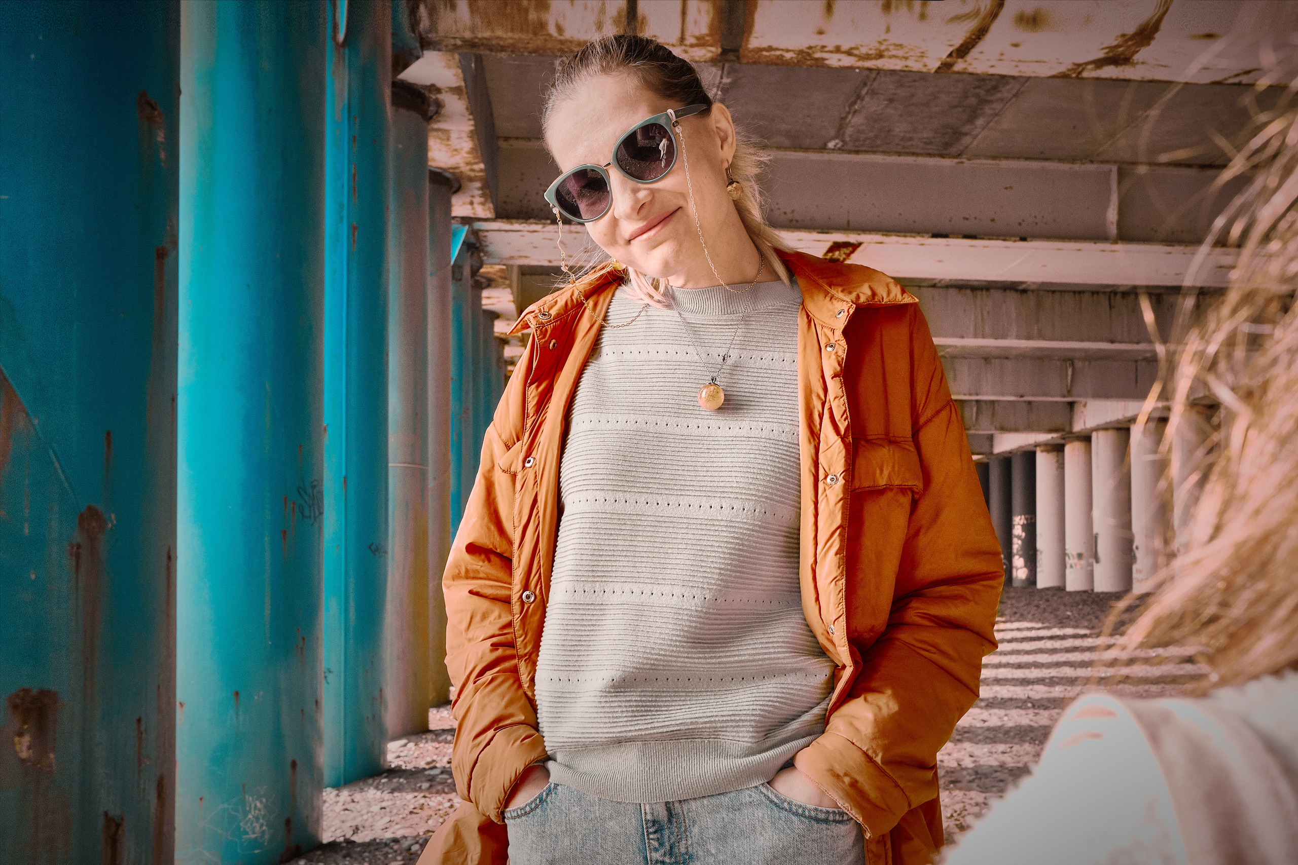 Adler, Imeretinsky seaport. Woman with a half smile in a relaxed pose. Against the background of the columns that hold the port embankment. (Адлер, Имеретинский морской порт. Женщина с полуулыбкой в расслабленной позе. На фоне колонн, удерживающих набережную порта.)