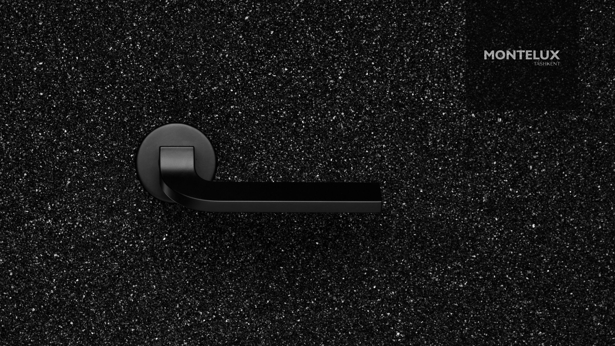 Профессиональная рекламная фотосъёмка дверной ручки MONTELUX в Ташкенте — чёрный матовый металл на текстурном фоне. Фото для каталога и брендбука.