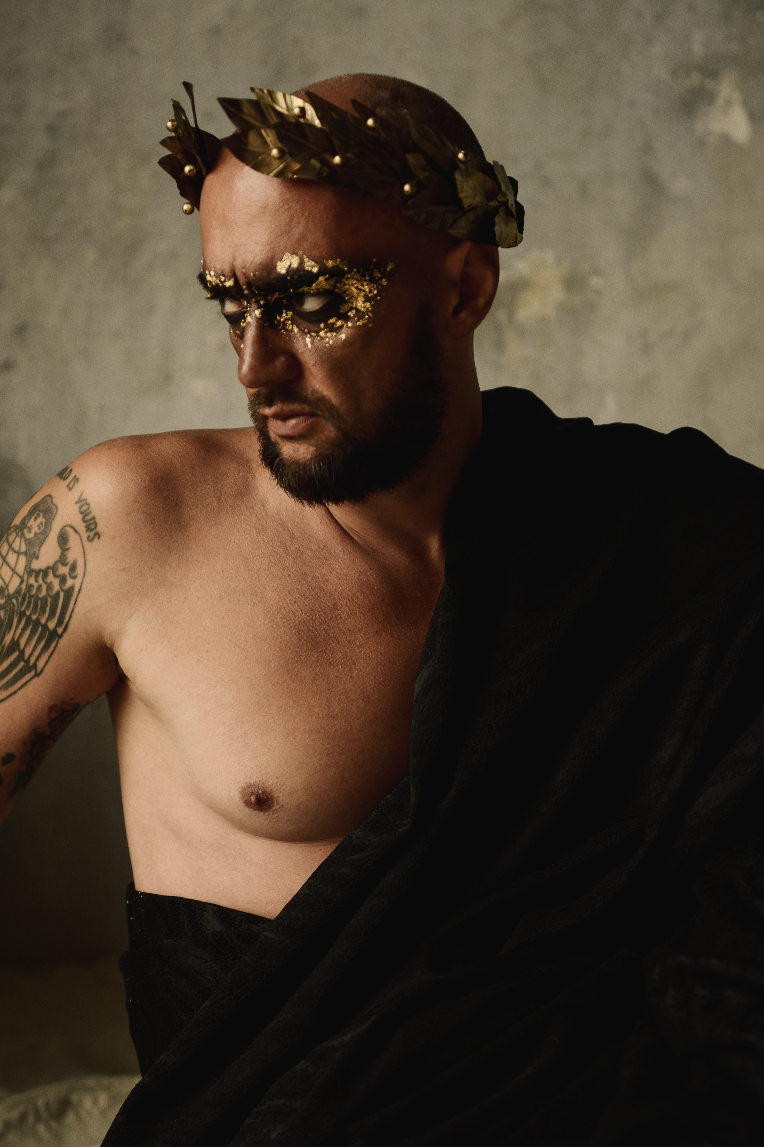 Мужчина в лавровом венке среди песка в образе римского императора 