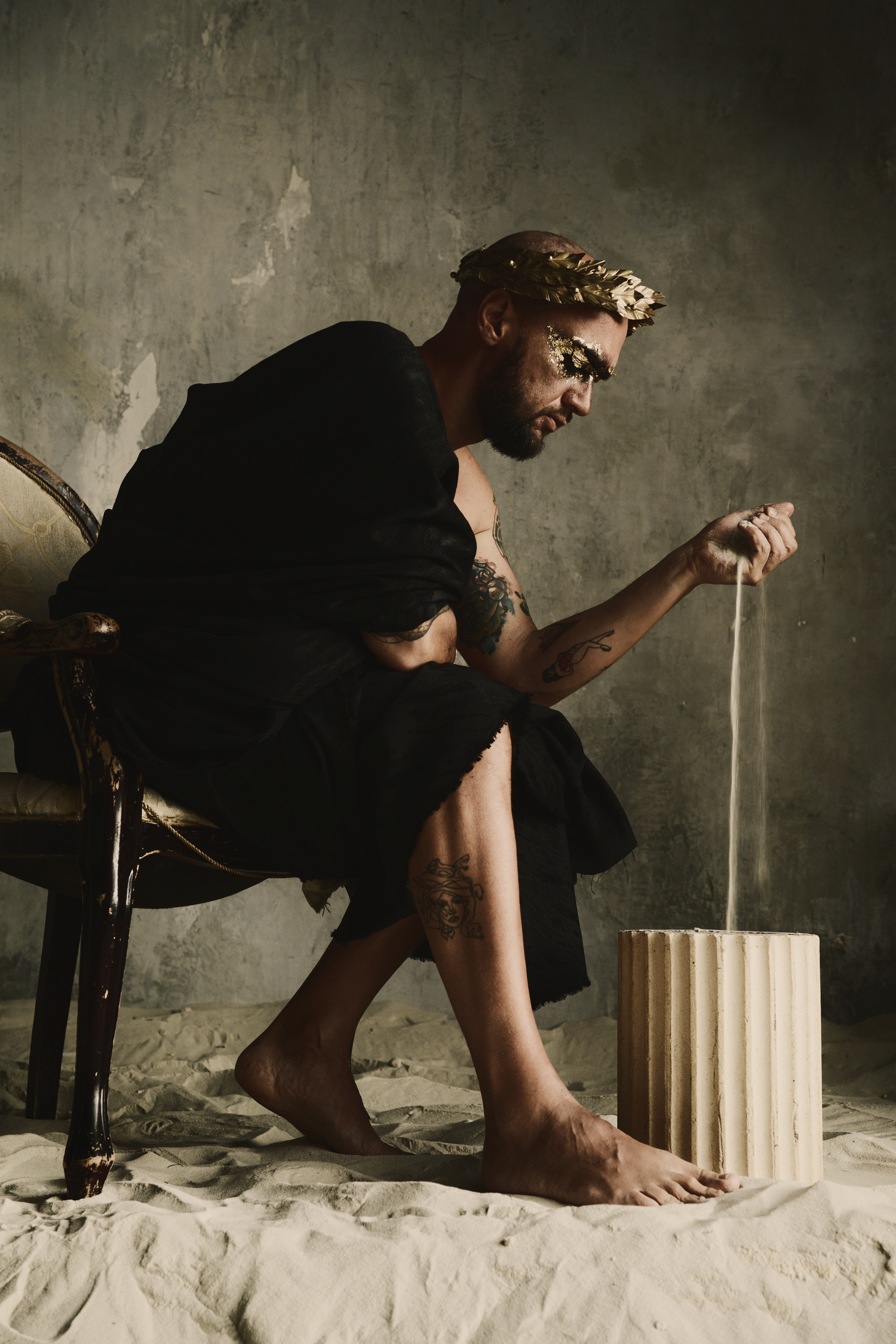 Мужчина в лавровом венке среди песка в образе римского императора 