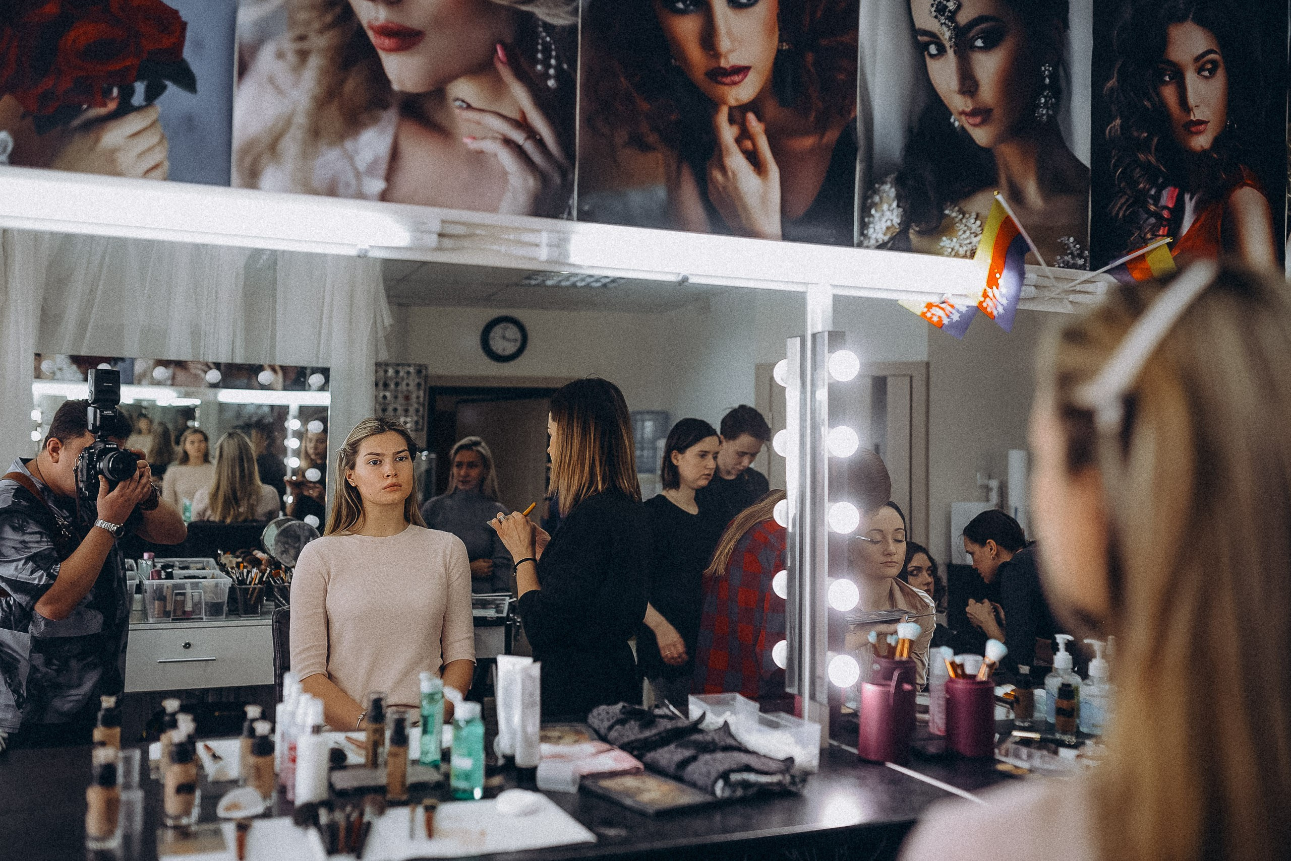 Портрет через зеркало с подсветкой: подготовка модели к фотосессии в гримерной.