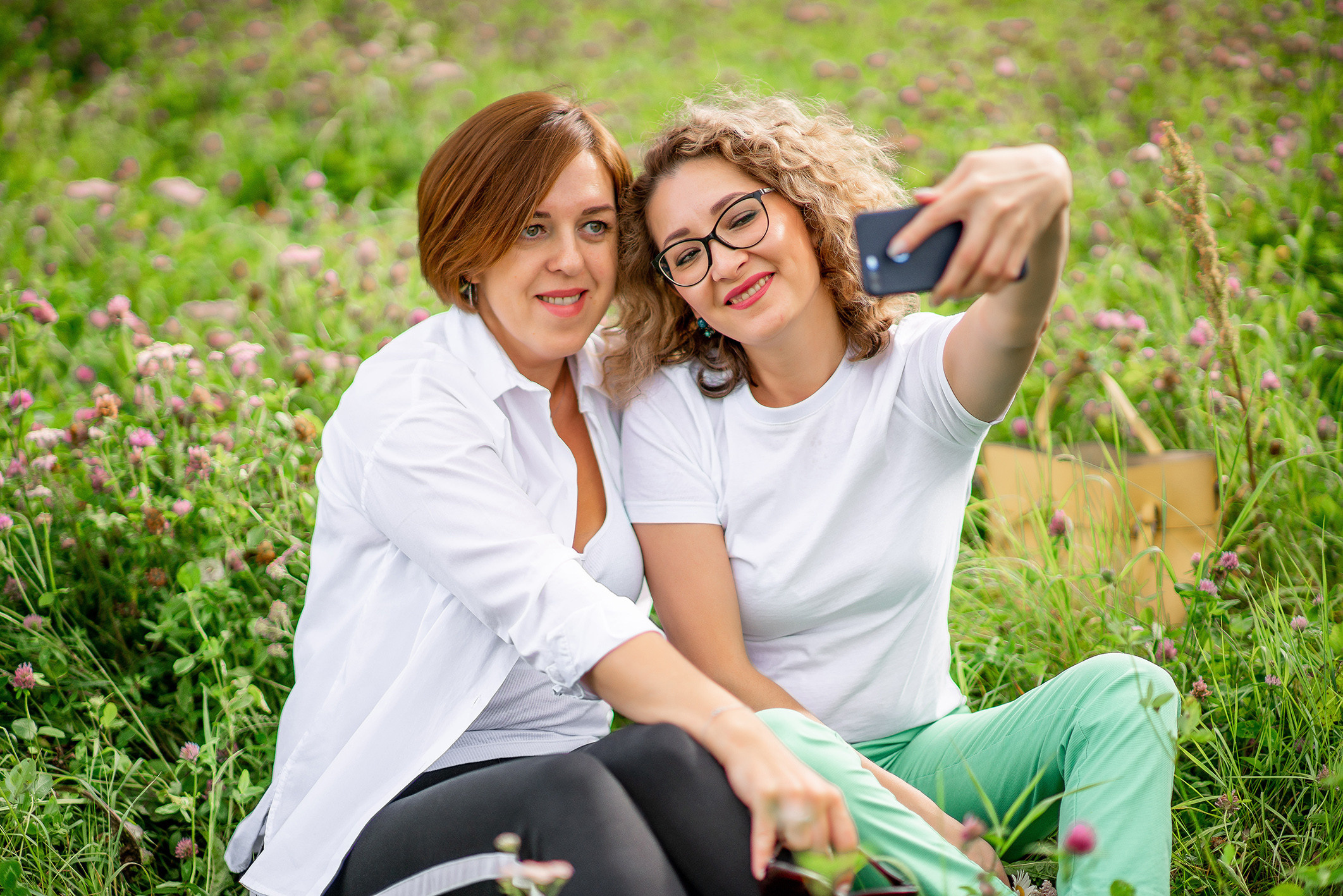 подруги улыбаются сидят на скамье  летом