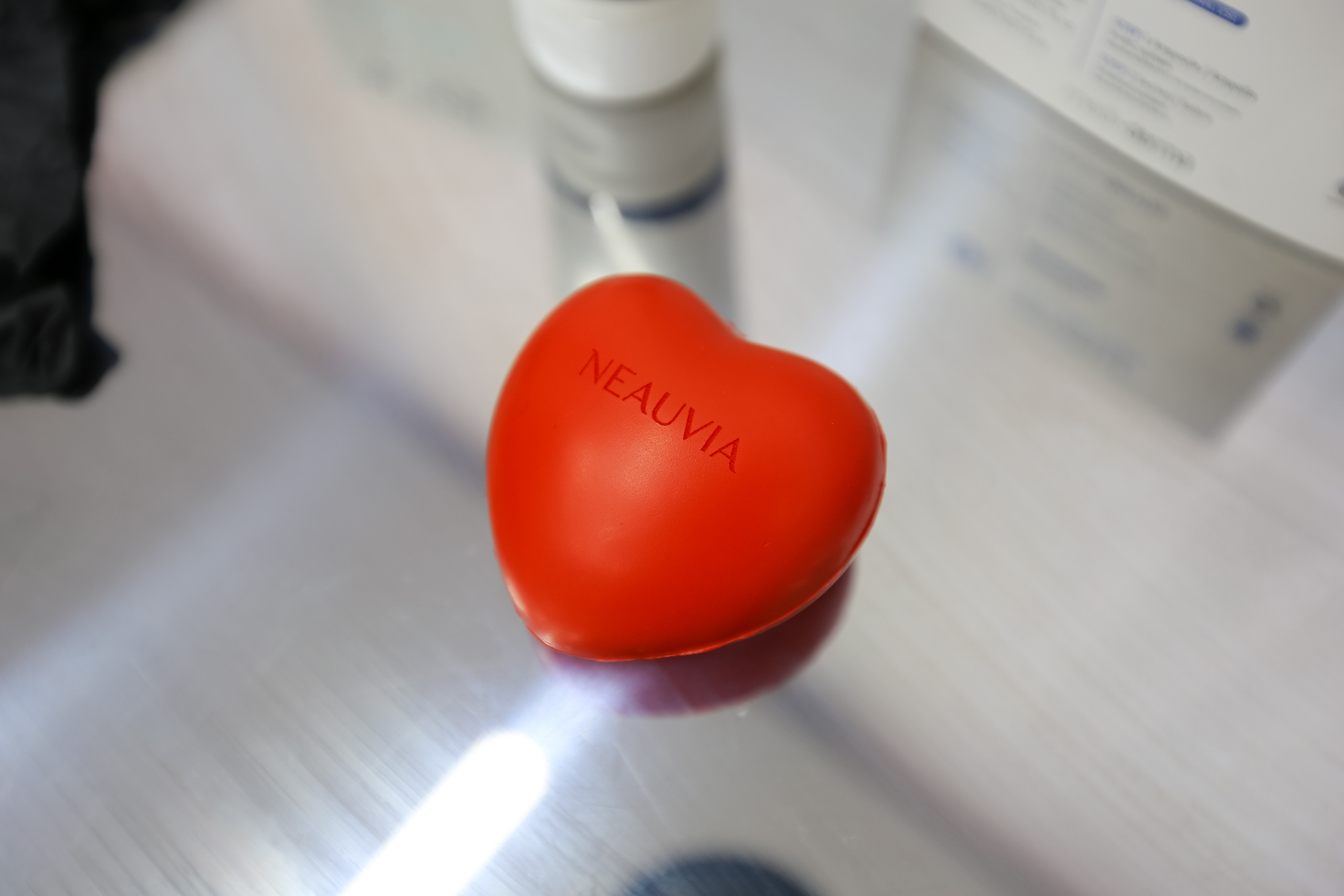 Игрушка антистресс в виде красного сердца на стеклянном столе. Стоматология Воронеж.