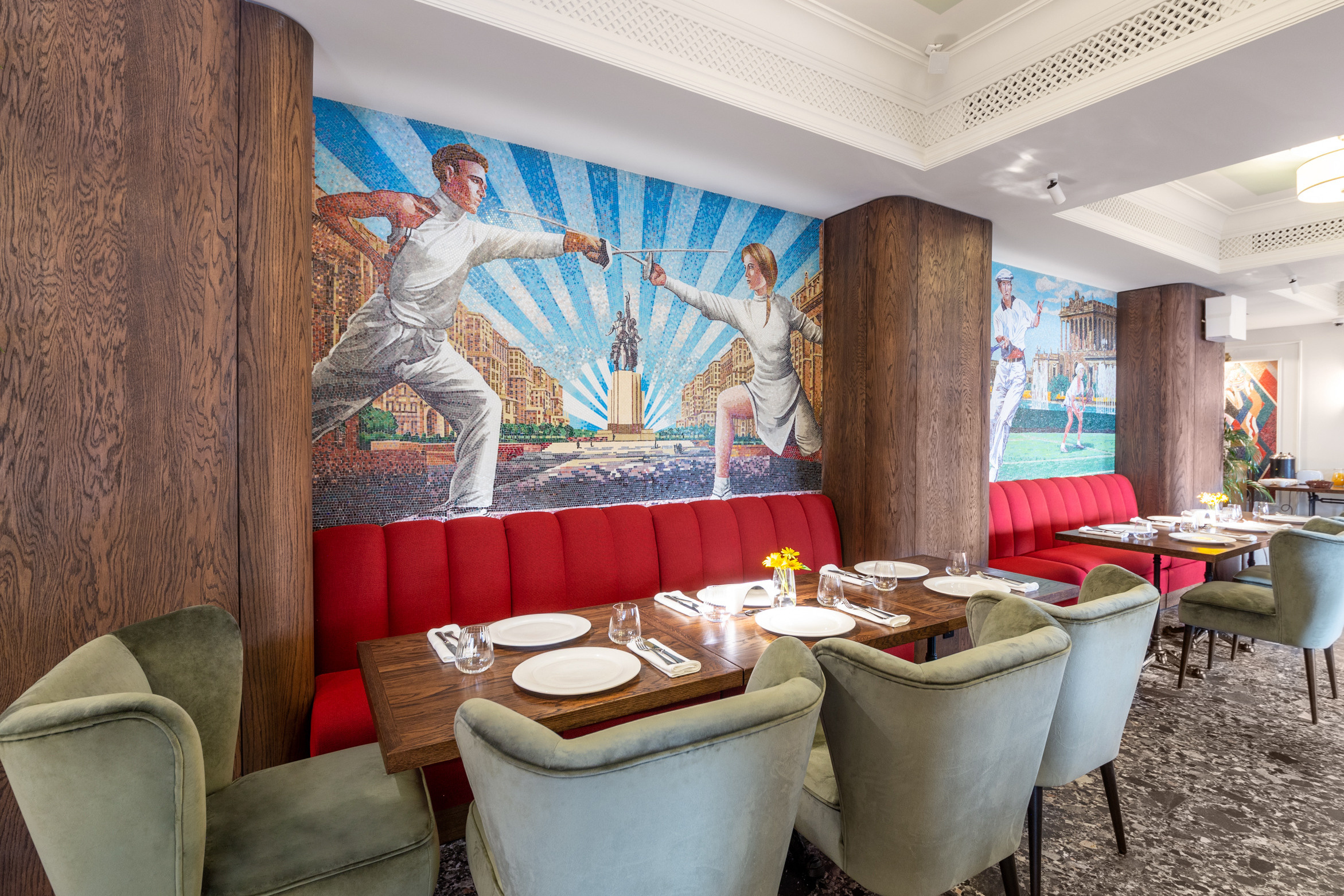 Красный большой диван у стены с мозаикой с советским сюжетом. Картина в советском стиле. Интерьерное фото в Воронеже.