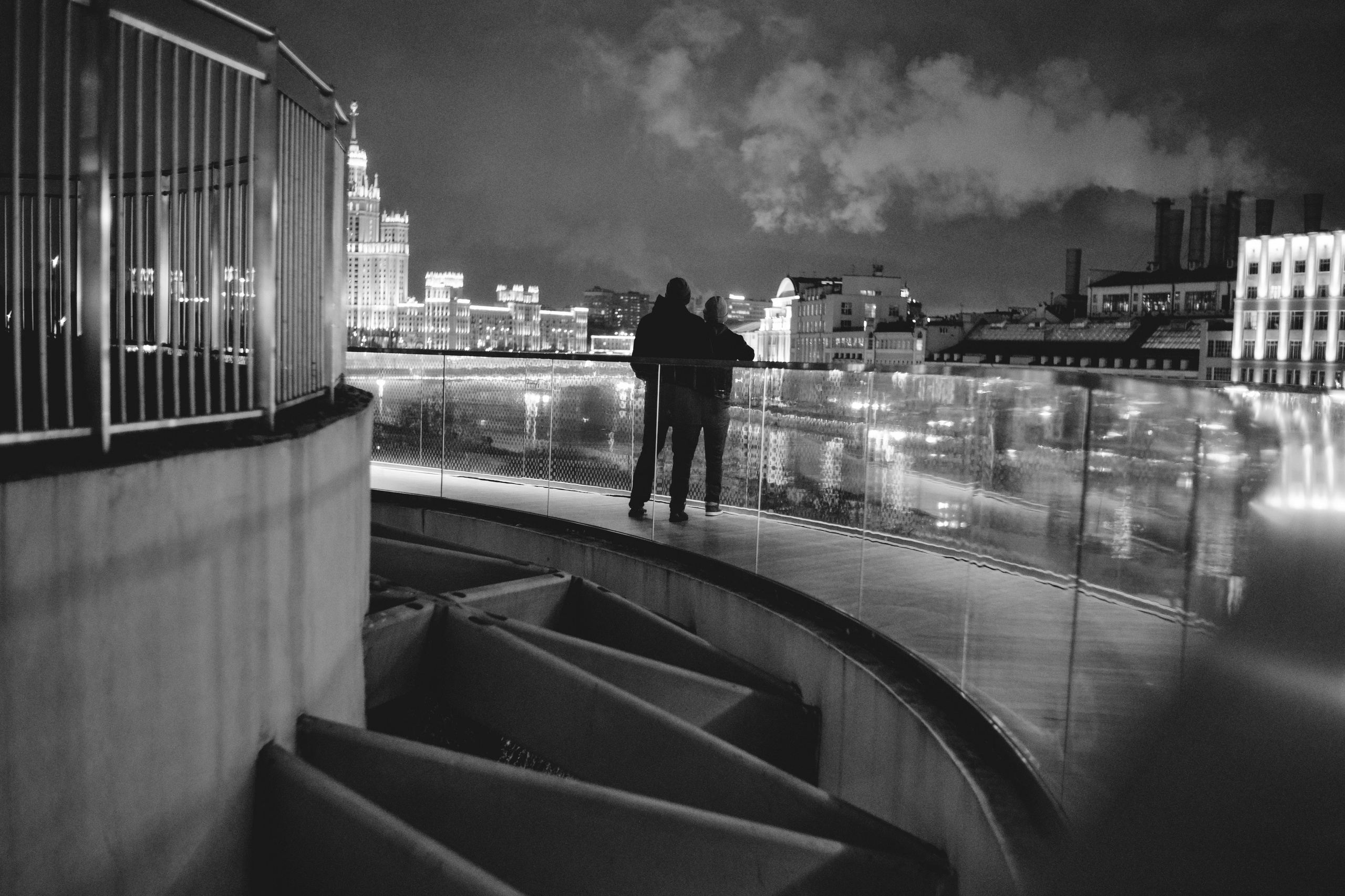 два человека в парке Зарядье на фоне высотки на Котельнической набережной