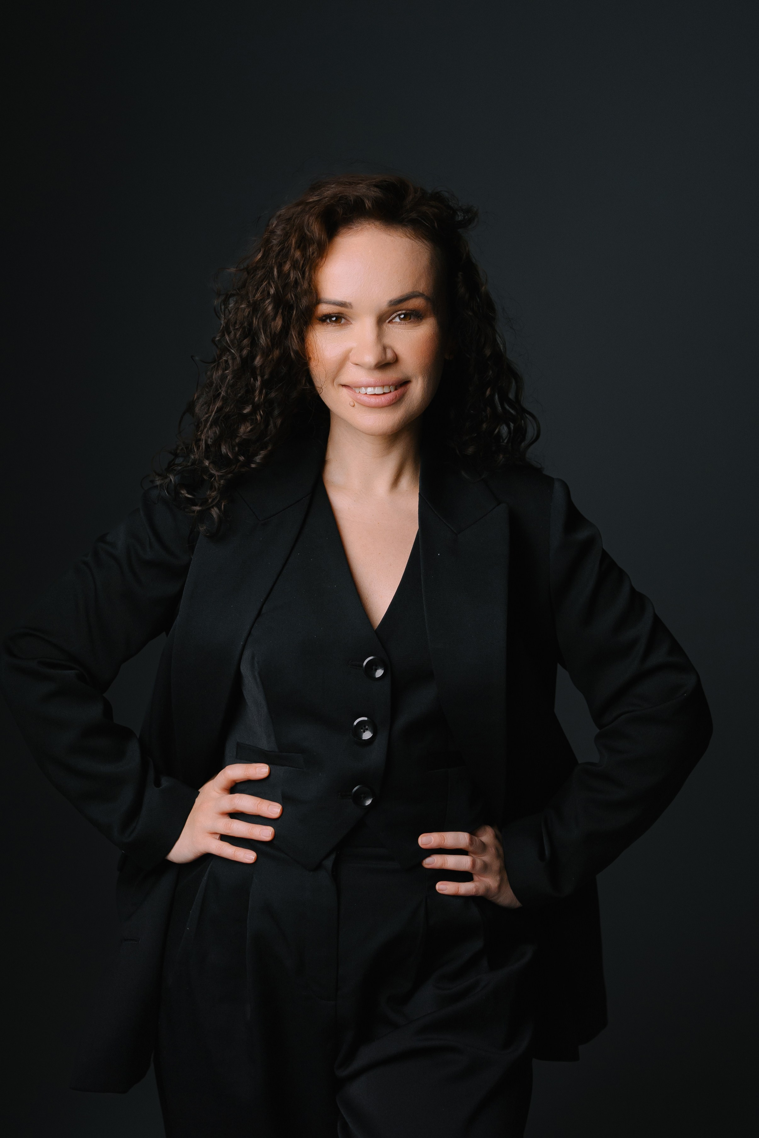 Девушка в классическом черном костюме в студийном интерьере, деловой женственный образ