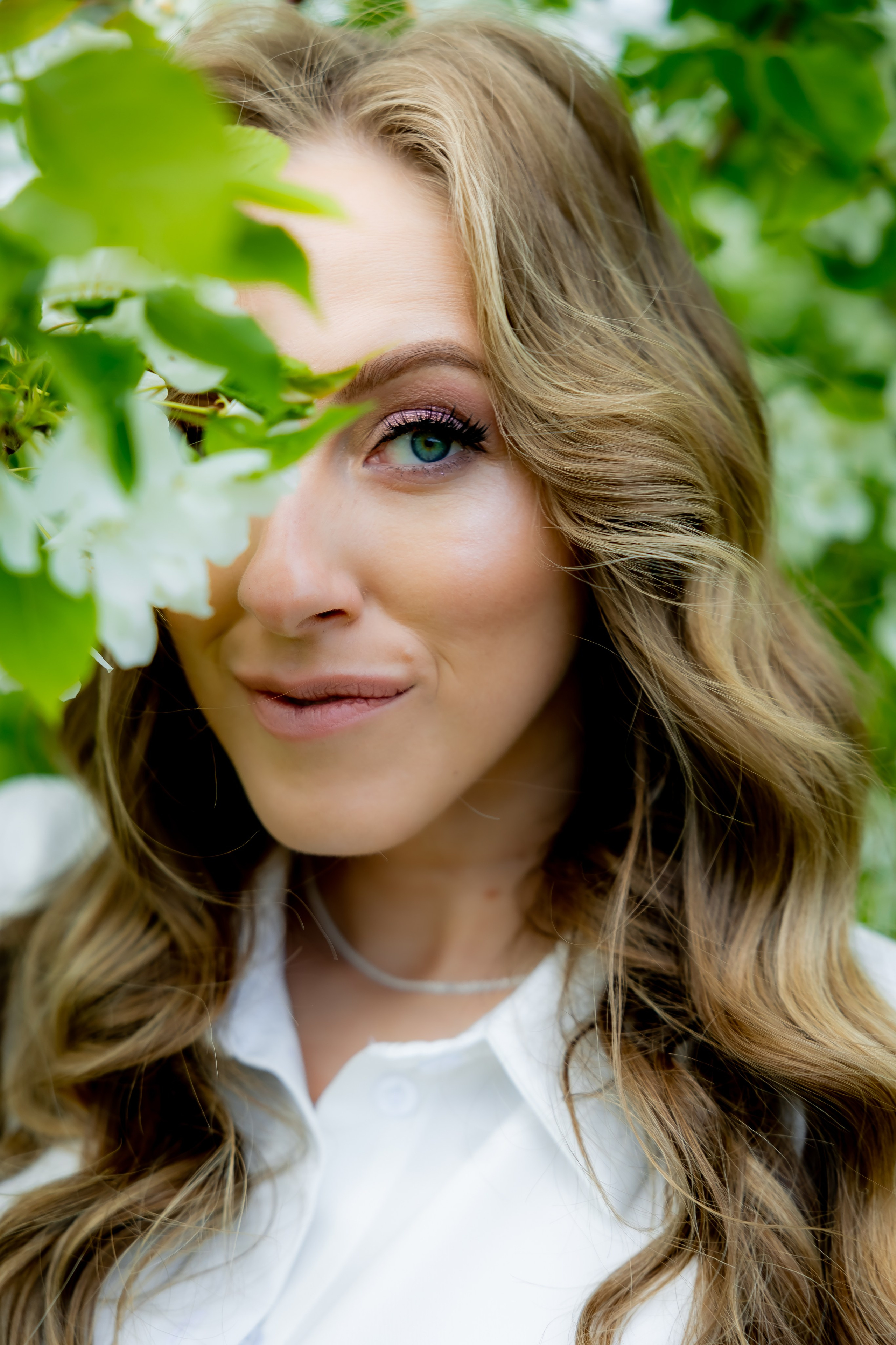 Женщина в белом платье на фоне цветущего поля и облачного неба