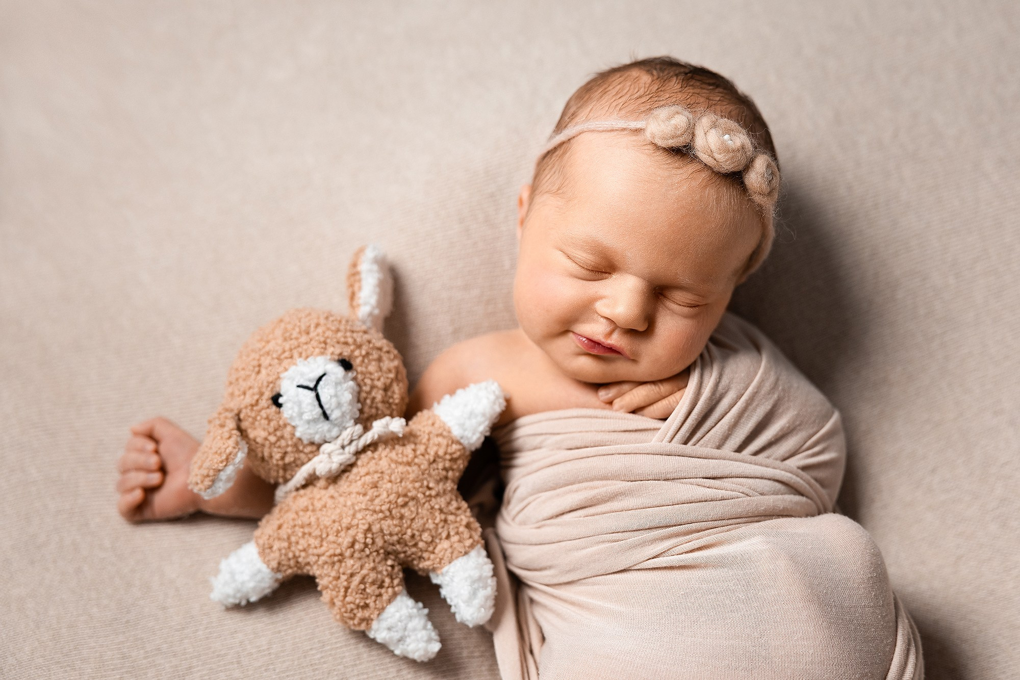 Малышка спит на спинке в обнимку с любимой игрушкой.