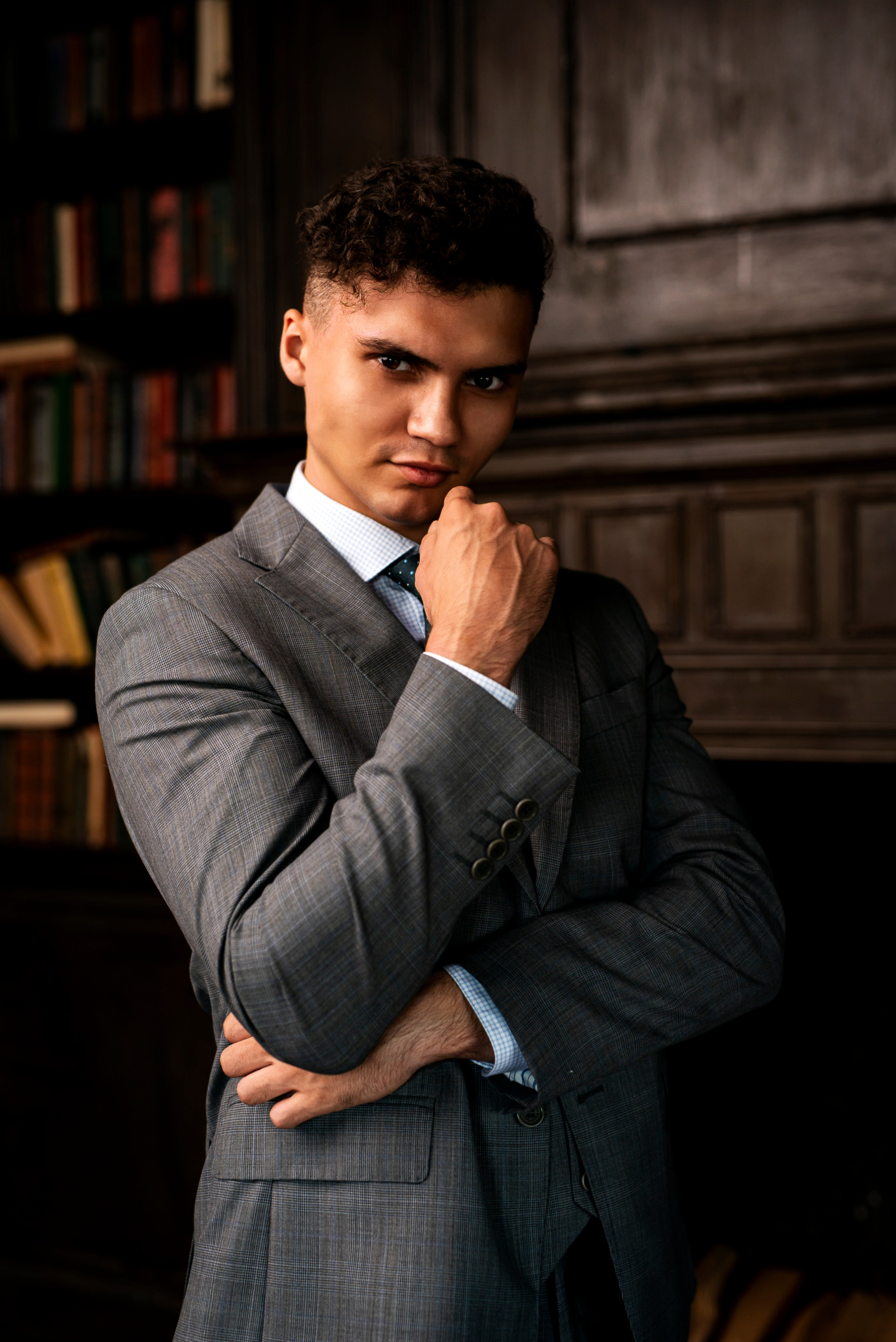 Человек в деловом костюме принимает позу для фотографии