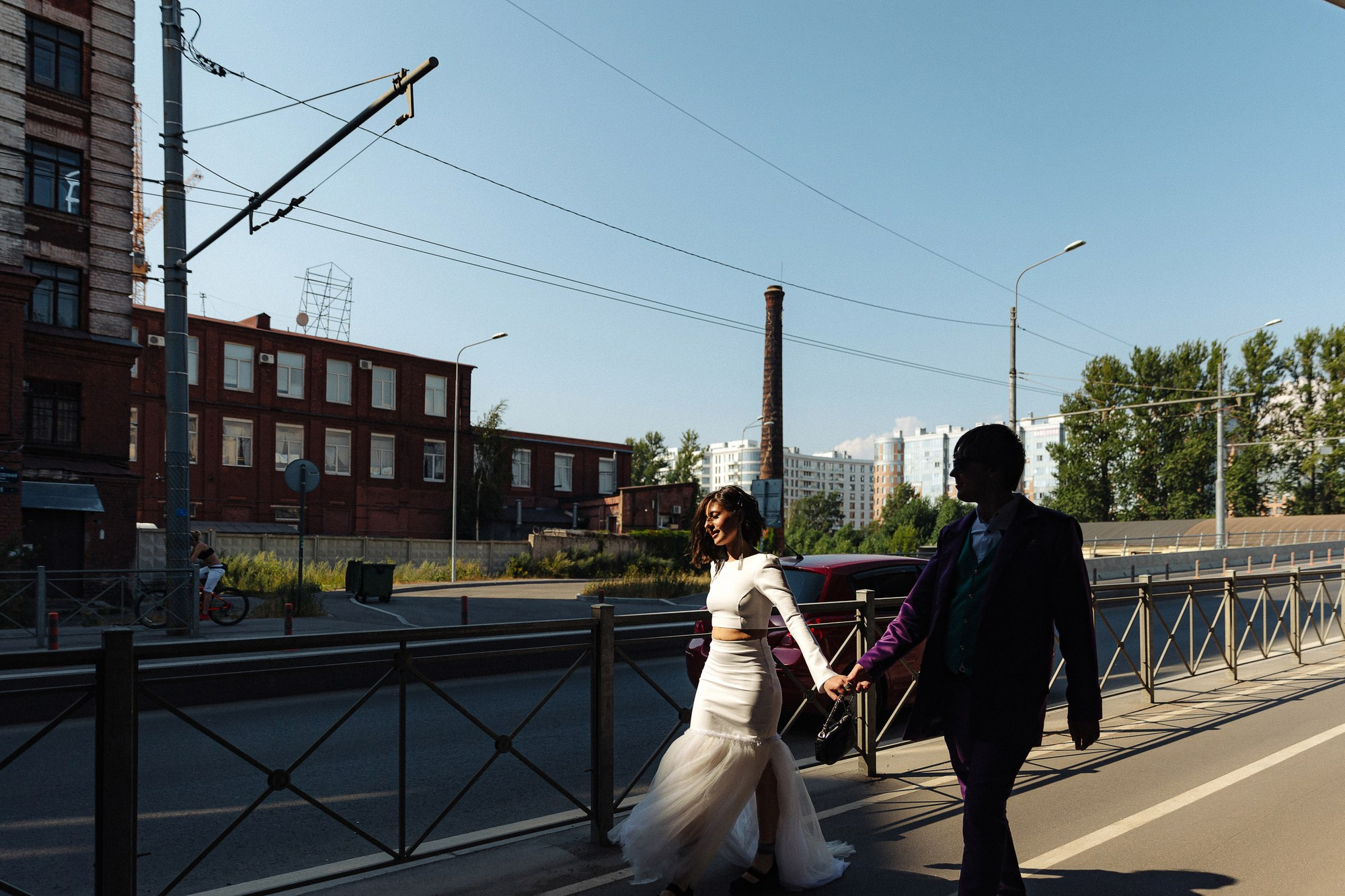 Стильные жених и невеста идут по тротуару