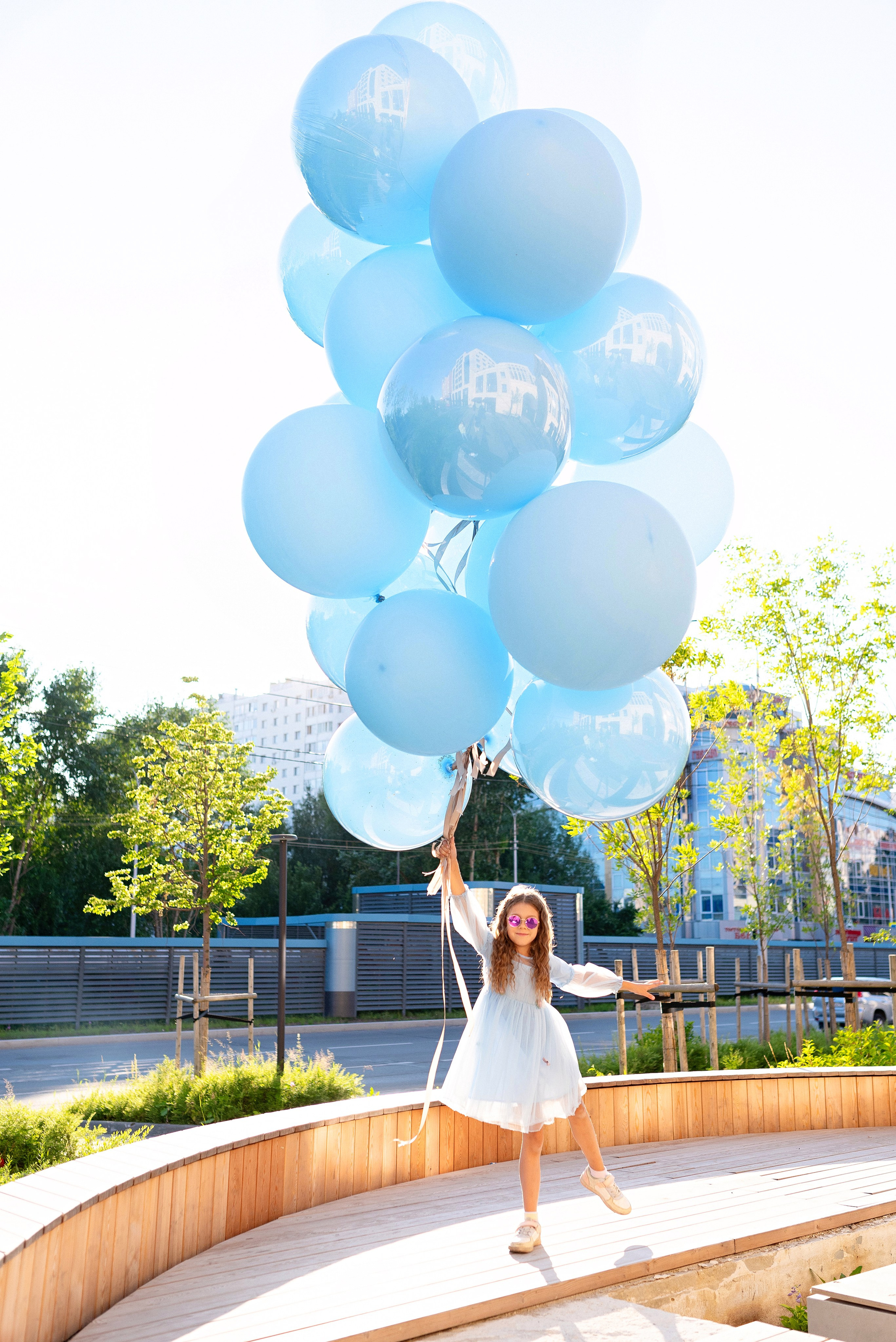 Огромные яркие воздушные шары от ШарЛэнд, парящие над живописным ландшафтом города Сургут, запечатленные профессиональным фотографом Анной Старцевой. Фото демонстрирует зрелищность мероприятия и атмосферу праздника, привлекая внимание зрителей красотой и масштабом события.