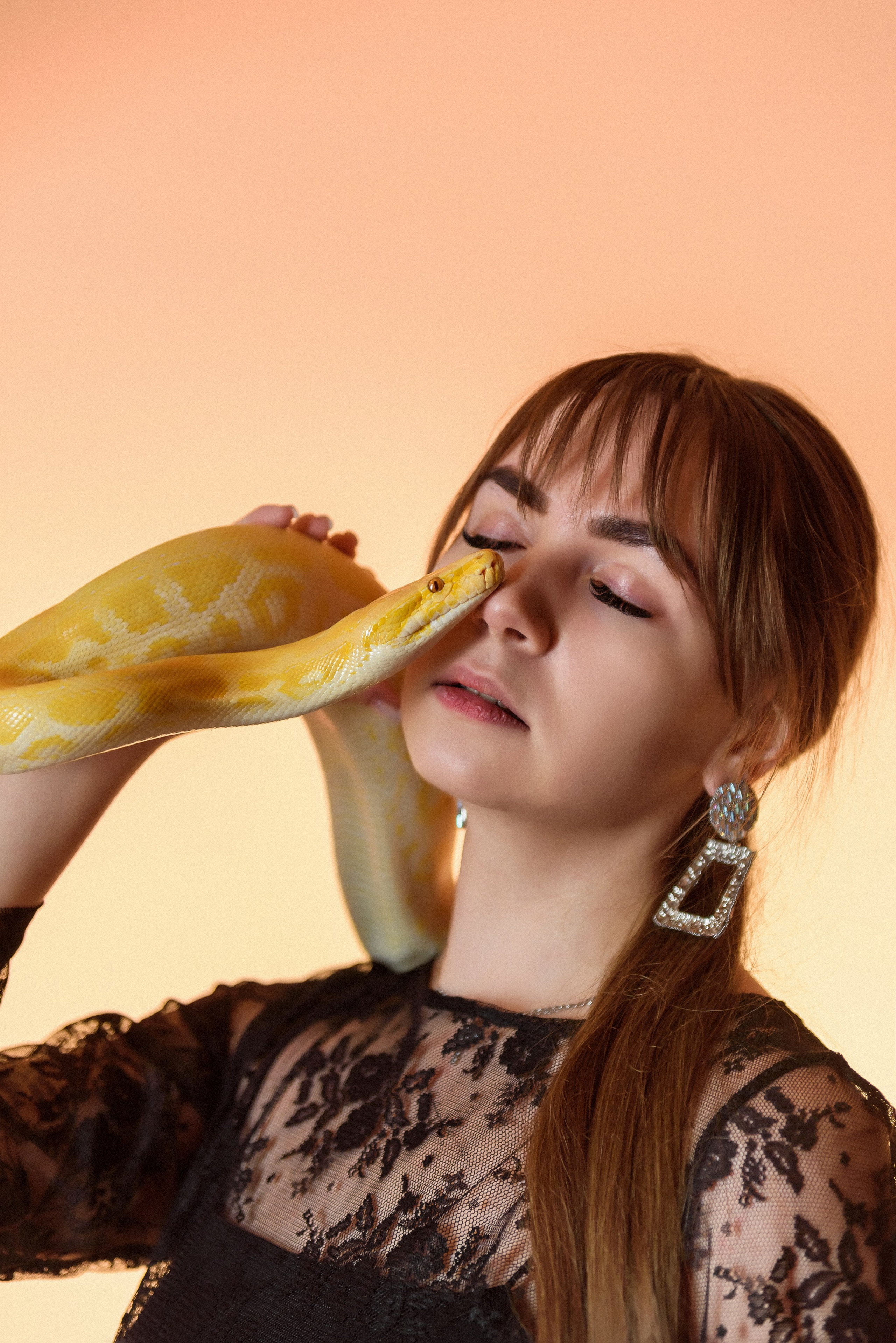 Красивая фотосессия со змеей в студии с цветным светом