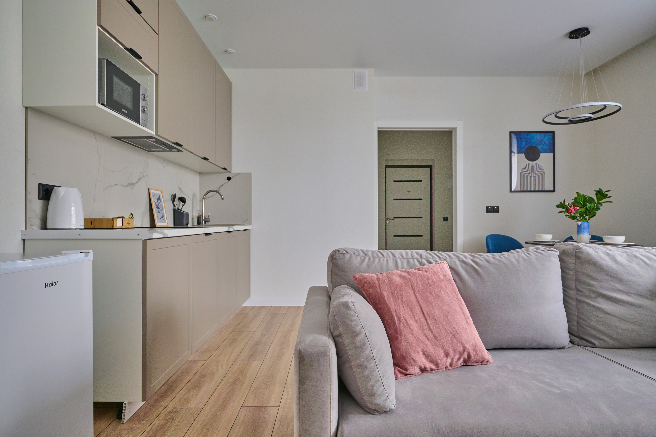 кухня в светлых оттенках  бежевый диван бежевые полки 