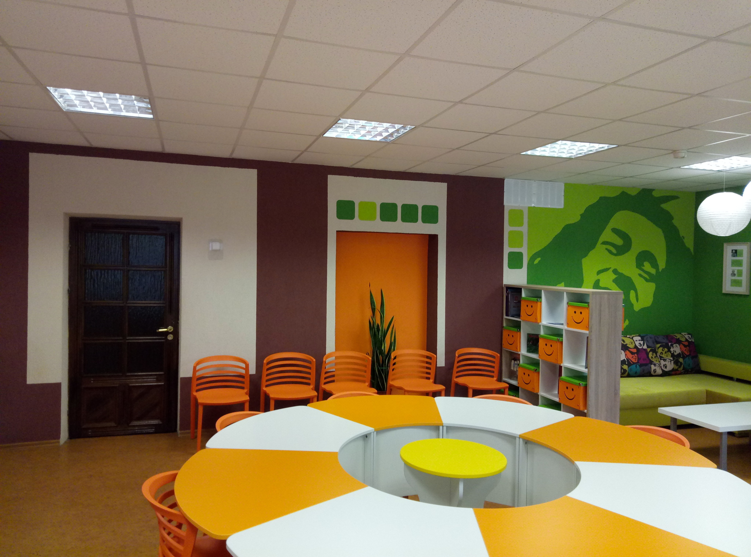 Длинноволосый мужчина весело улыбается. Роспись офиса международного сотрудничества