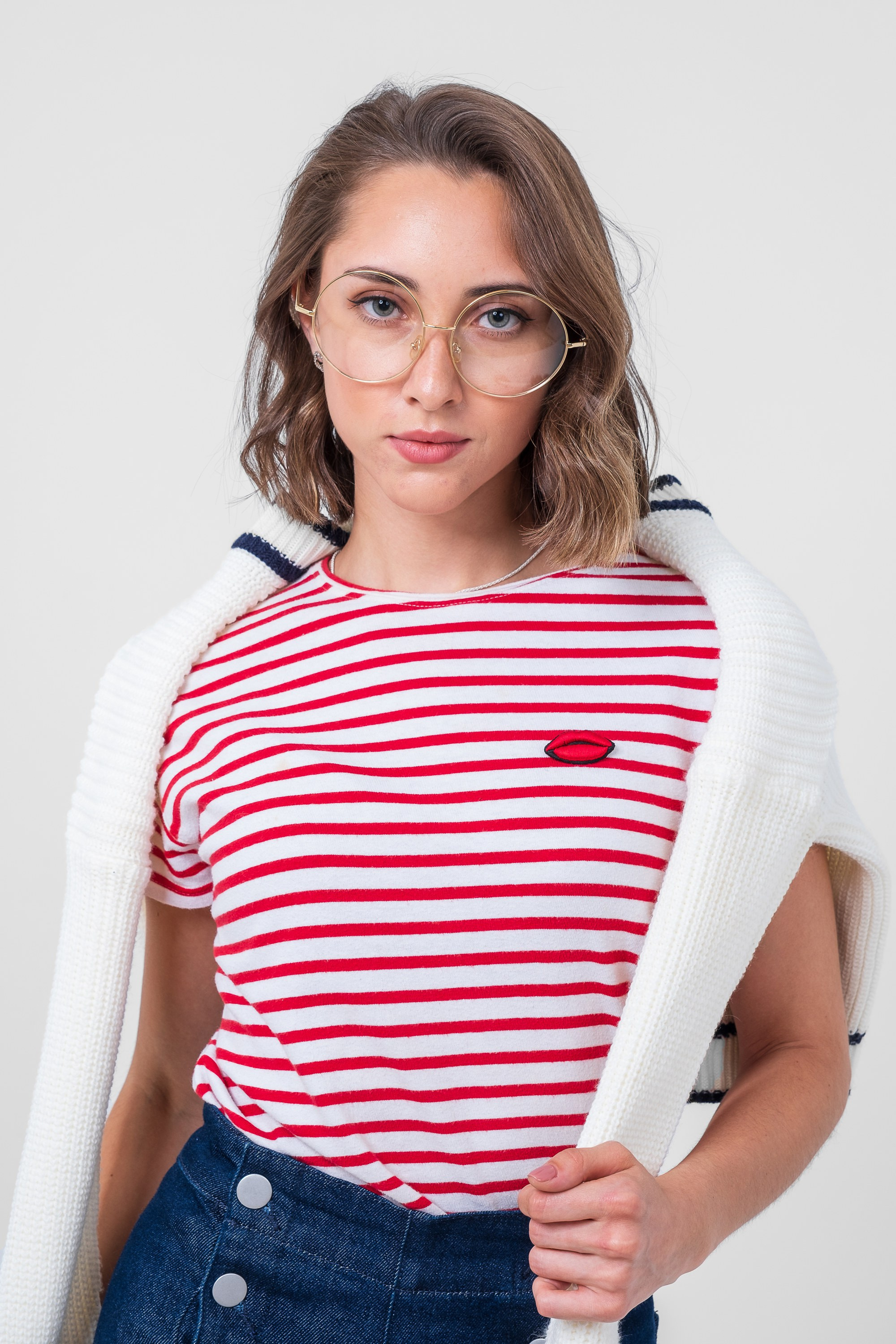 На изображении девушка в очках в полосатой футболке и широких джинсах с пуговицами.  Фото для маркетплейсов