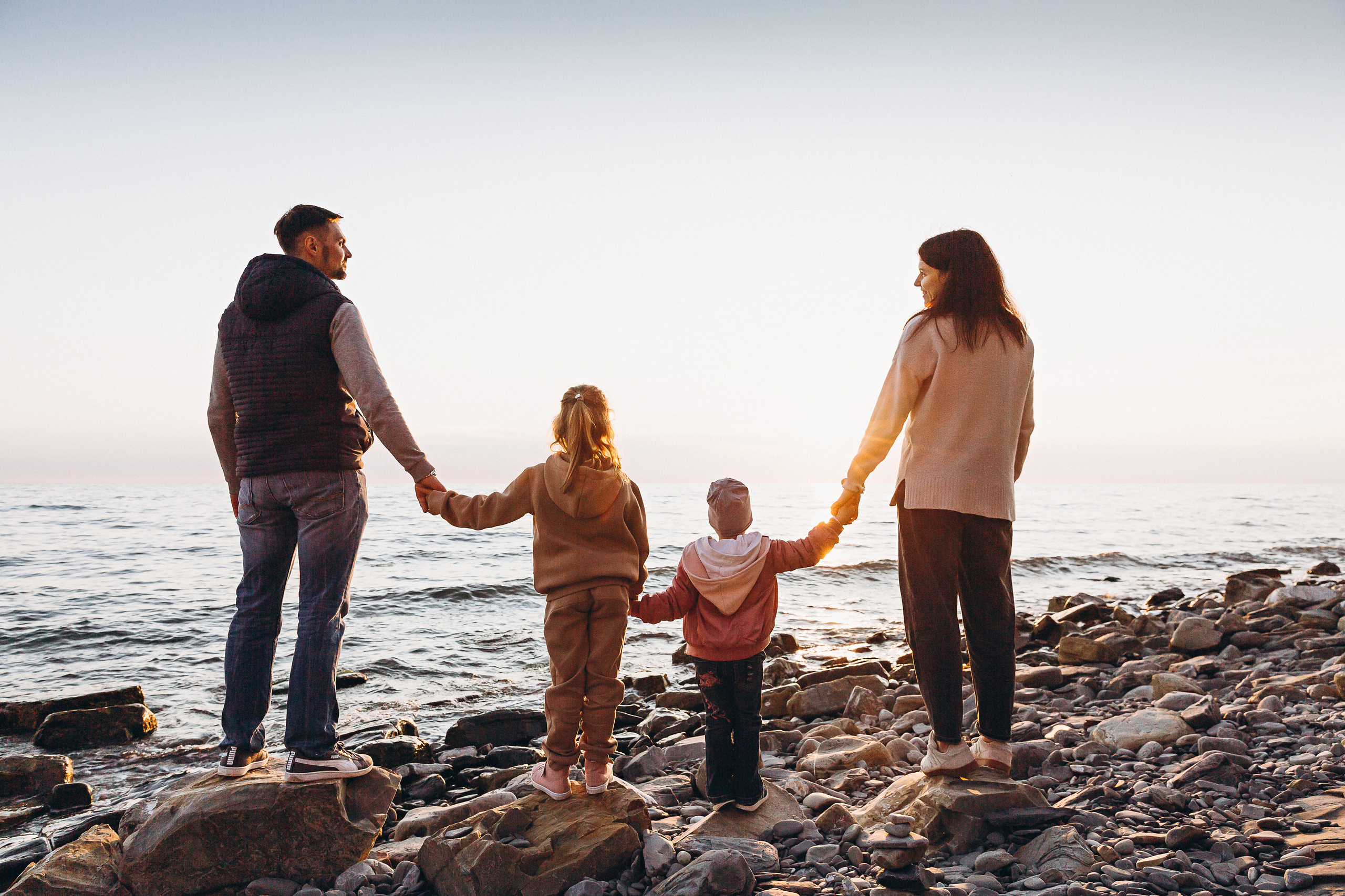 Семья провожает закат на берегу моря