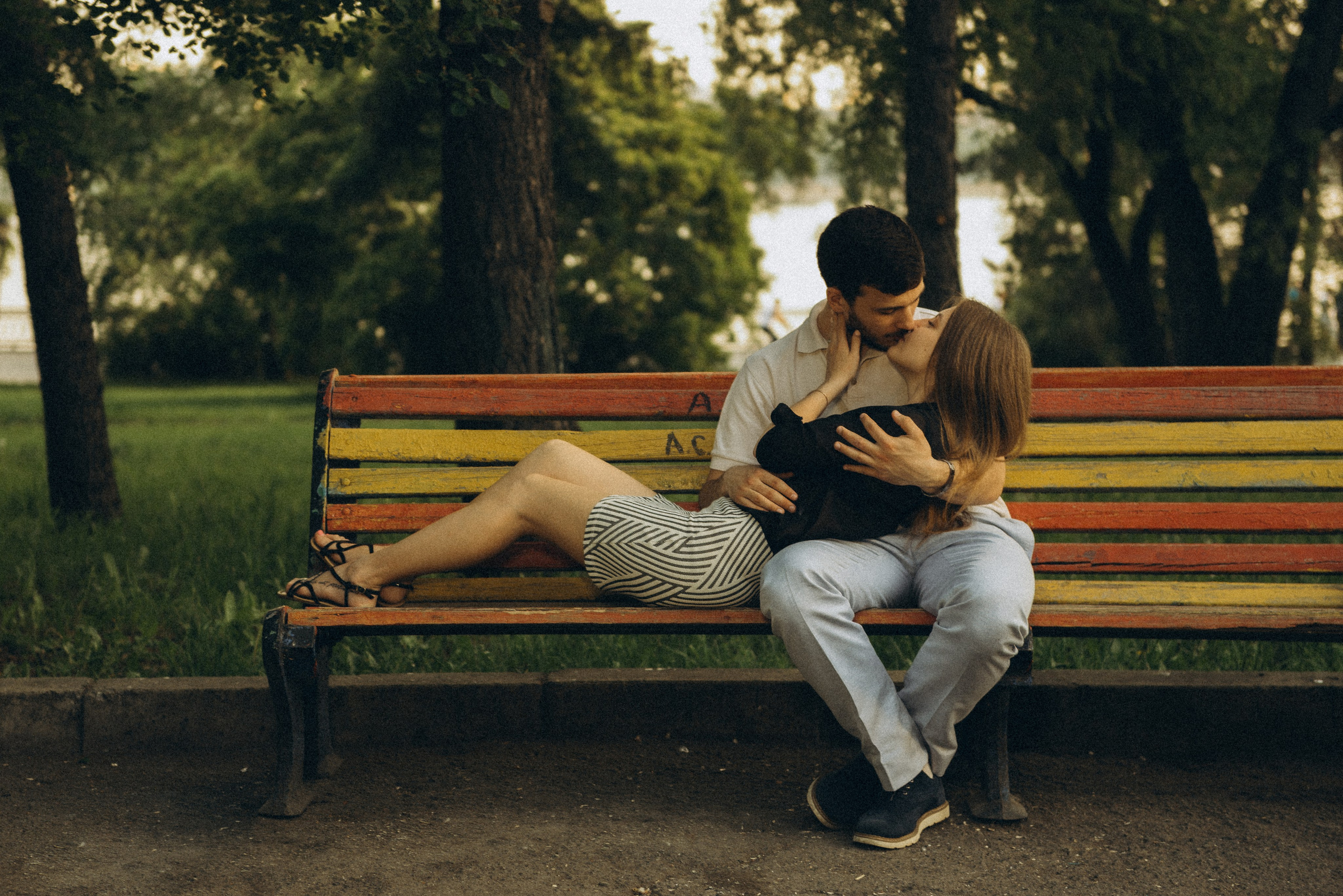 Поцелуй пары на яркой скамейке в парке набережной Оби. Идея для фотосессии в Новосибирске, съемка Василия Дана.