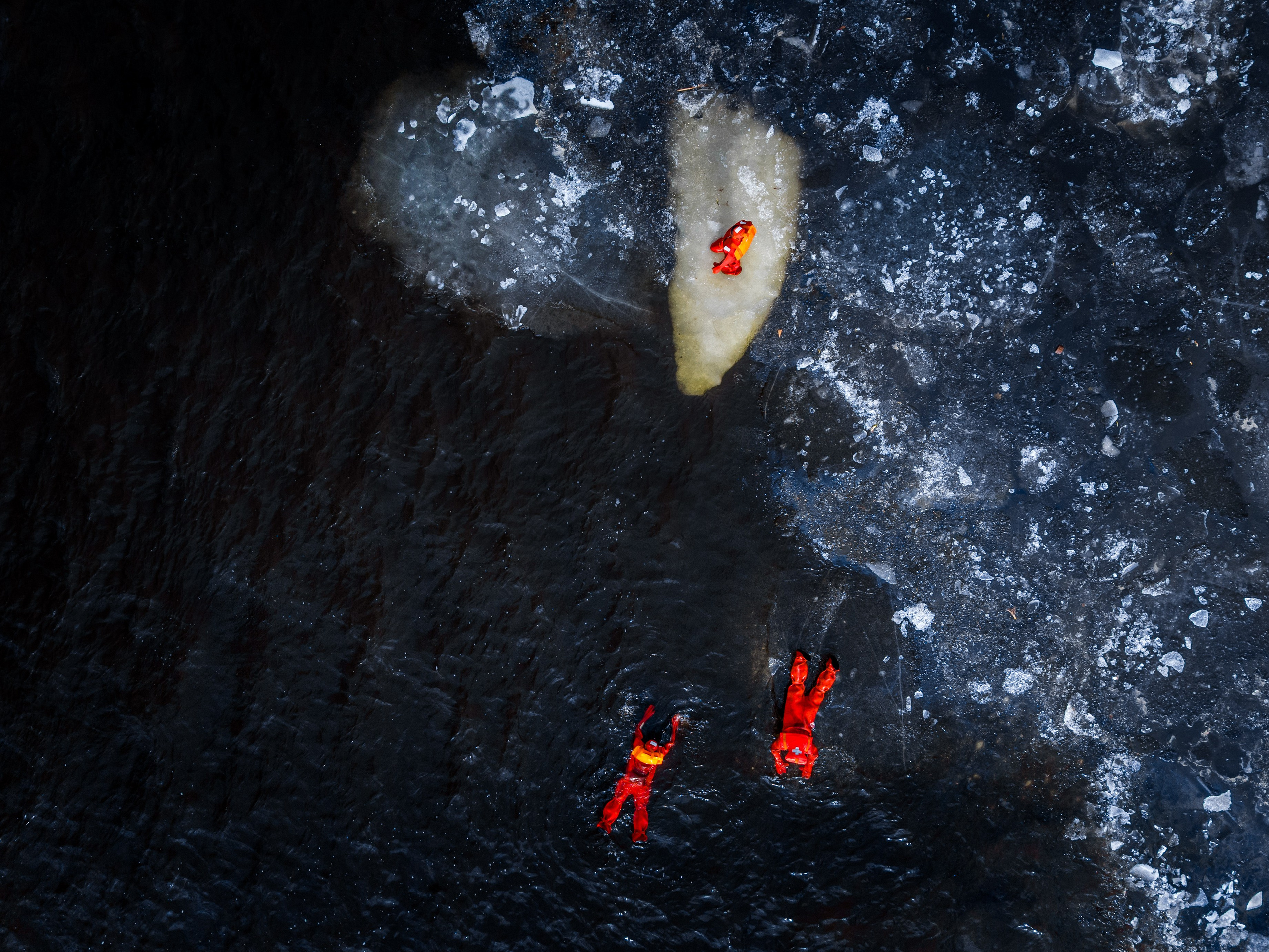 Люди купаются среди льдин, в спасательных оранжевых термо костюмах, айс флоатинг Ярославль