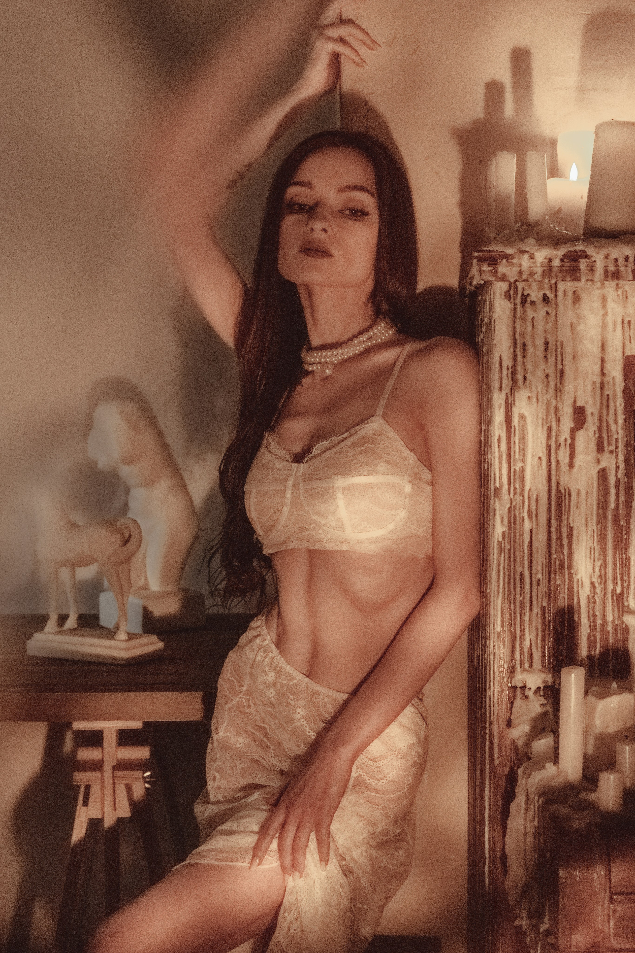 Женская фотосессия в кружевном белье в студии с винтажными элементами и свечами