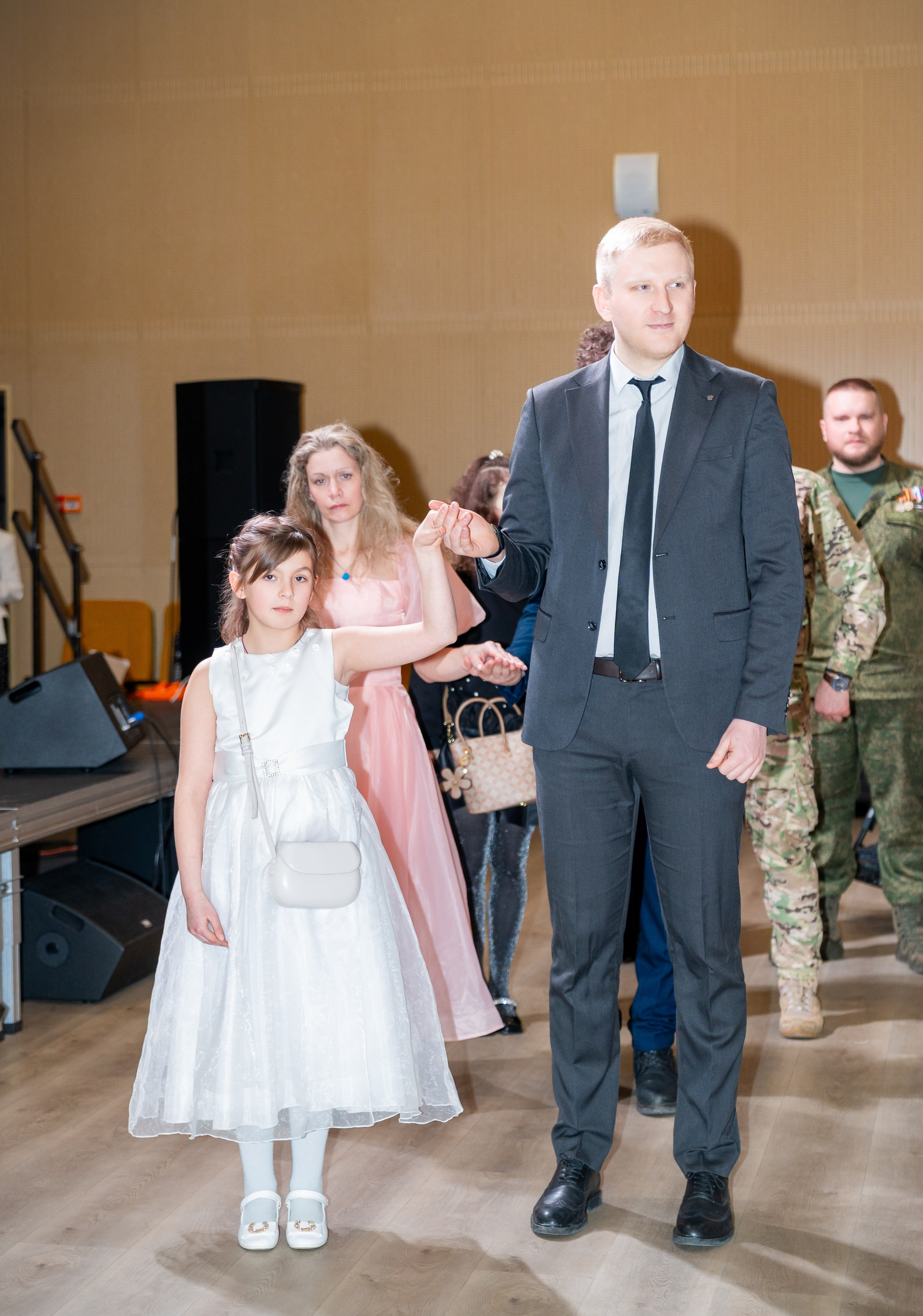 Мужчина в костюме ведёт маленькую девочку в белом платье на инклюзивном балу «Мы все равны». Фотография Мальцев Евгений.