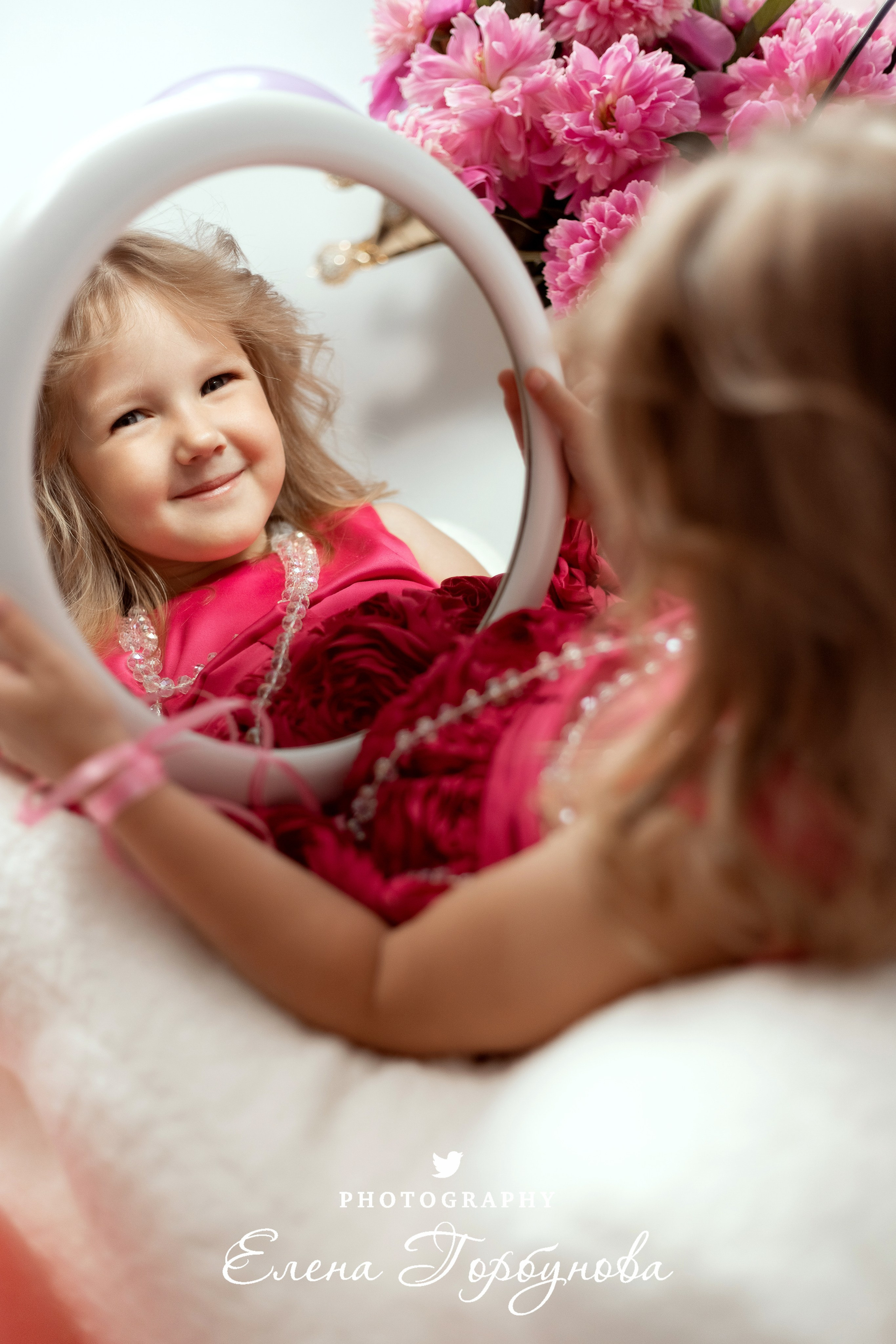 девочка 5 лет врозовом на фотосессии в студии с зеркалом