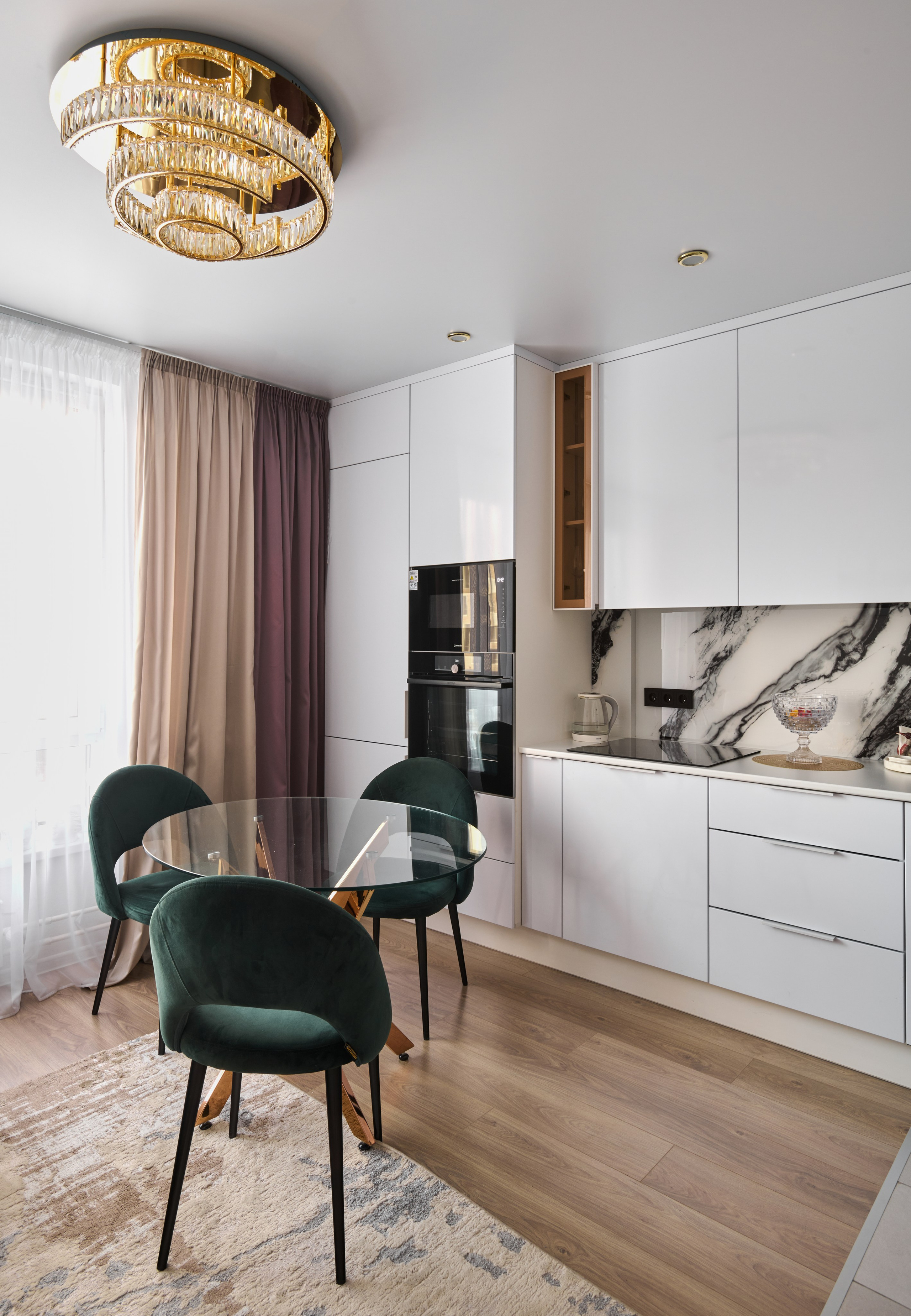 Белая кухня с мраморным фартуком, верхние шкафы, растение