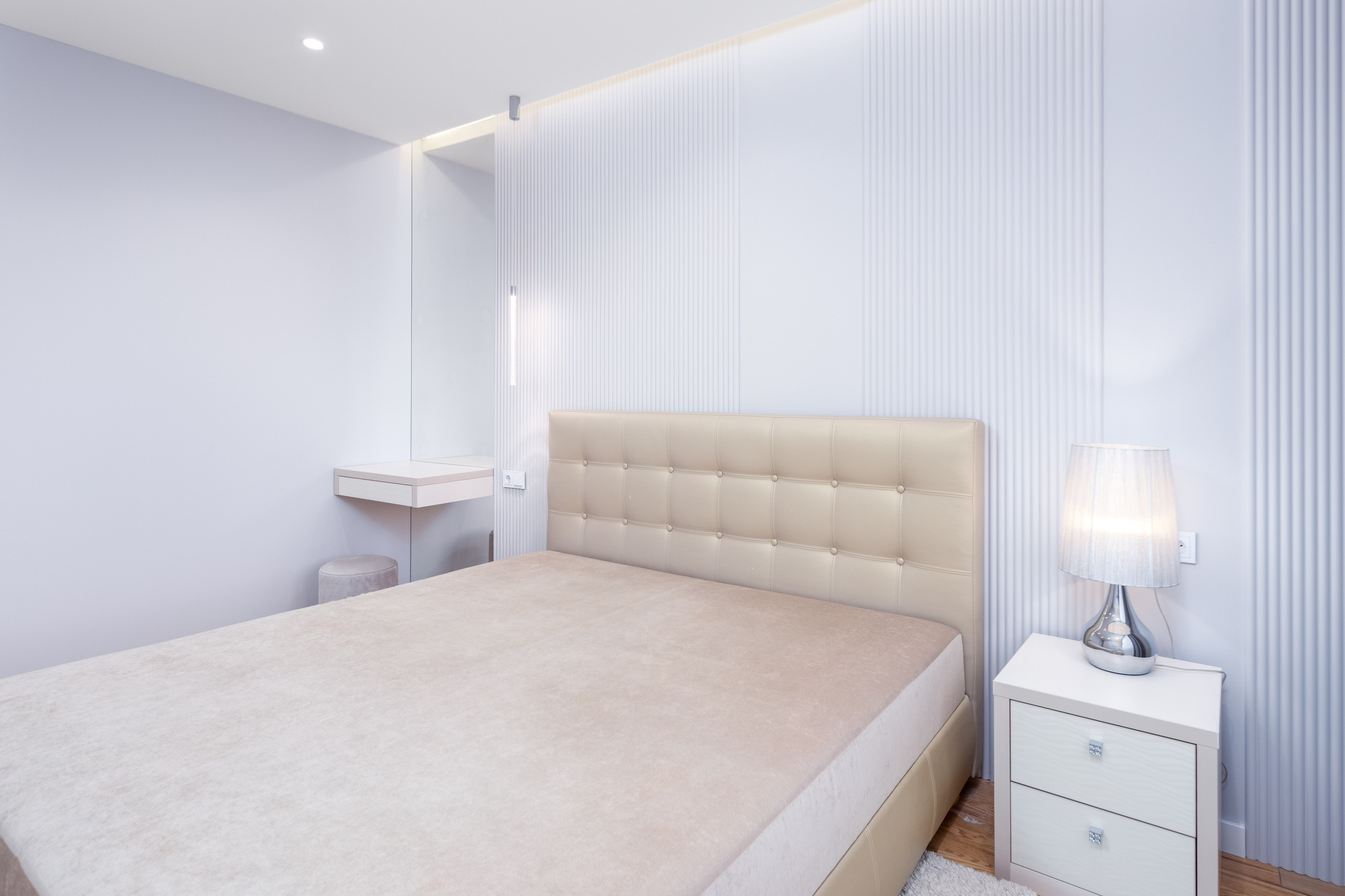 Кровать в мастер-спальне трехкомнатной квартиры в Минске