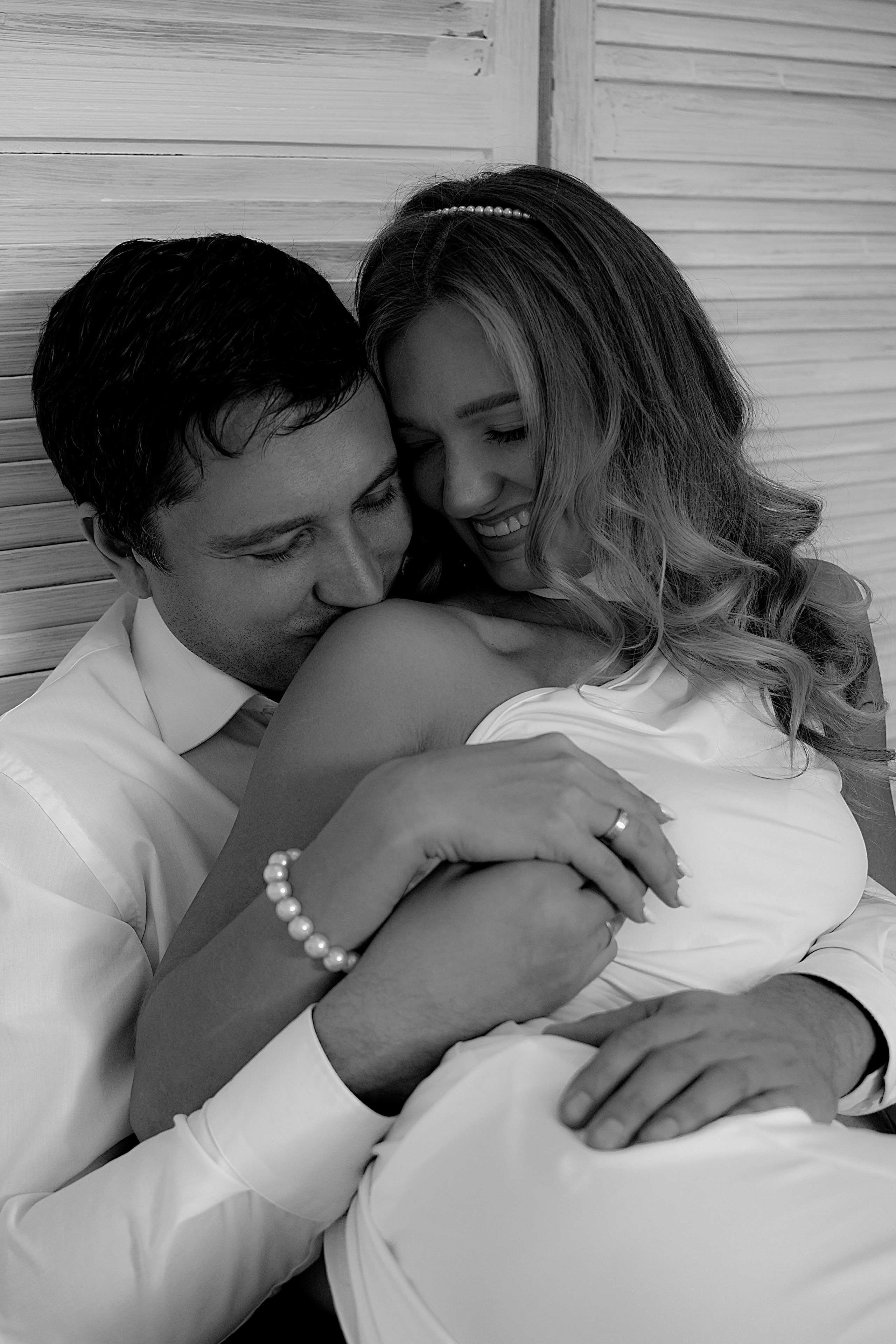 Жених целует плечо невесты и они смеются