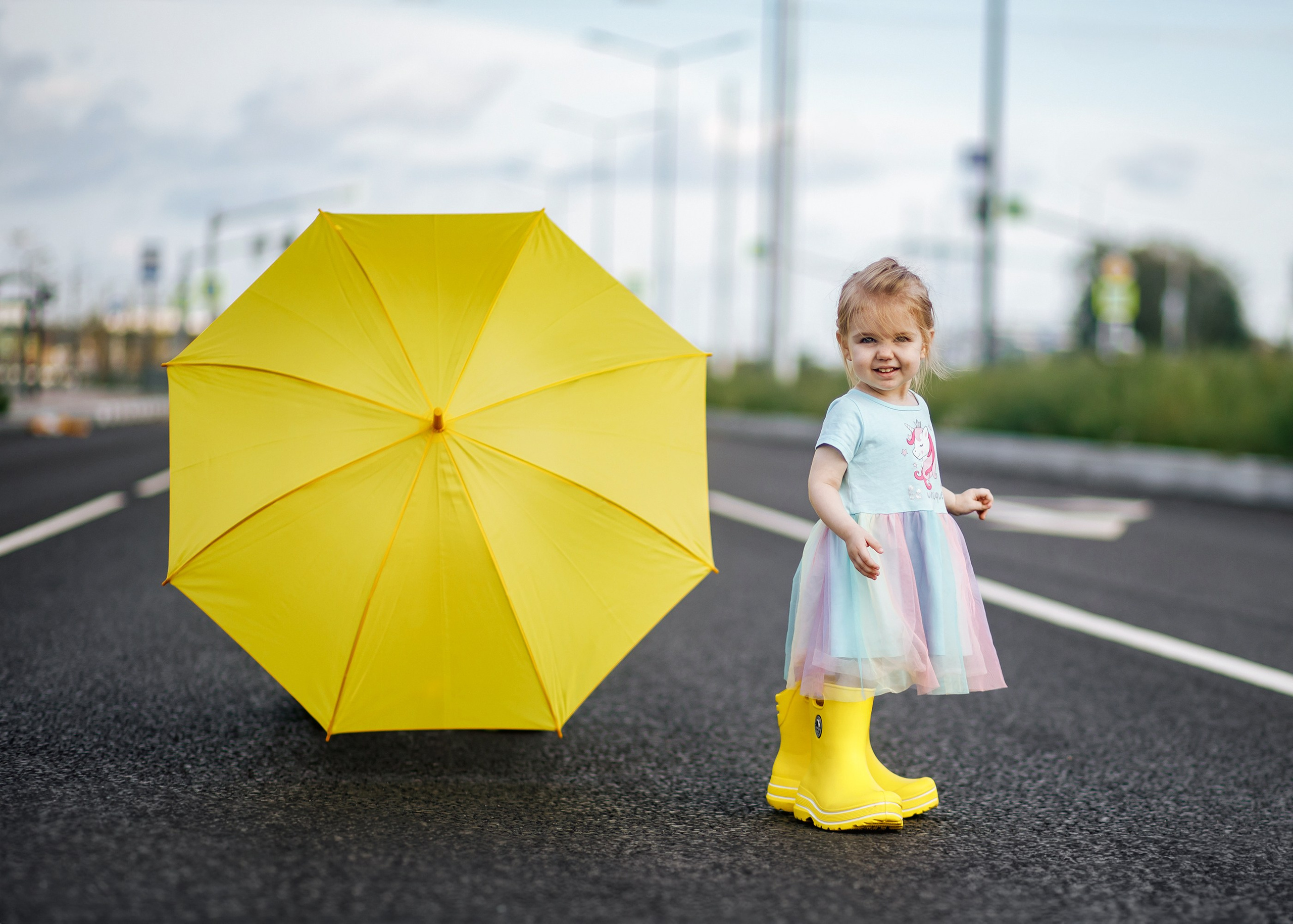 ребёнок в резиновых сапогах с желтым зонтом