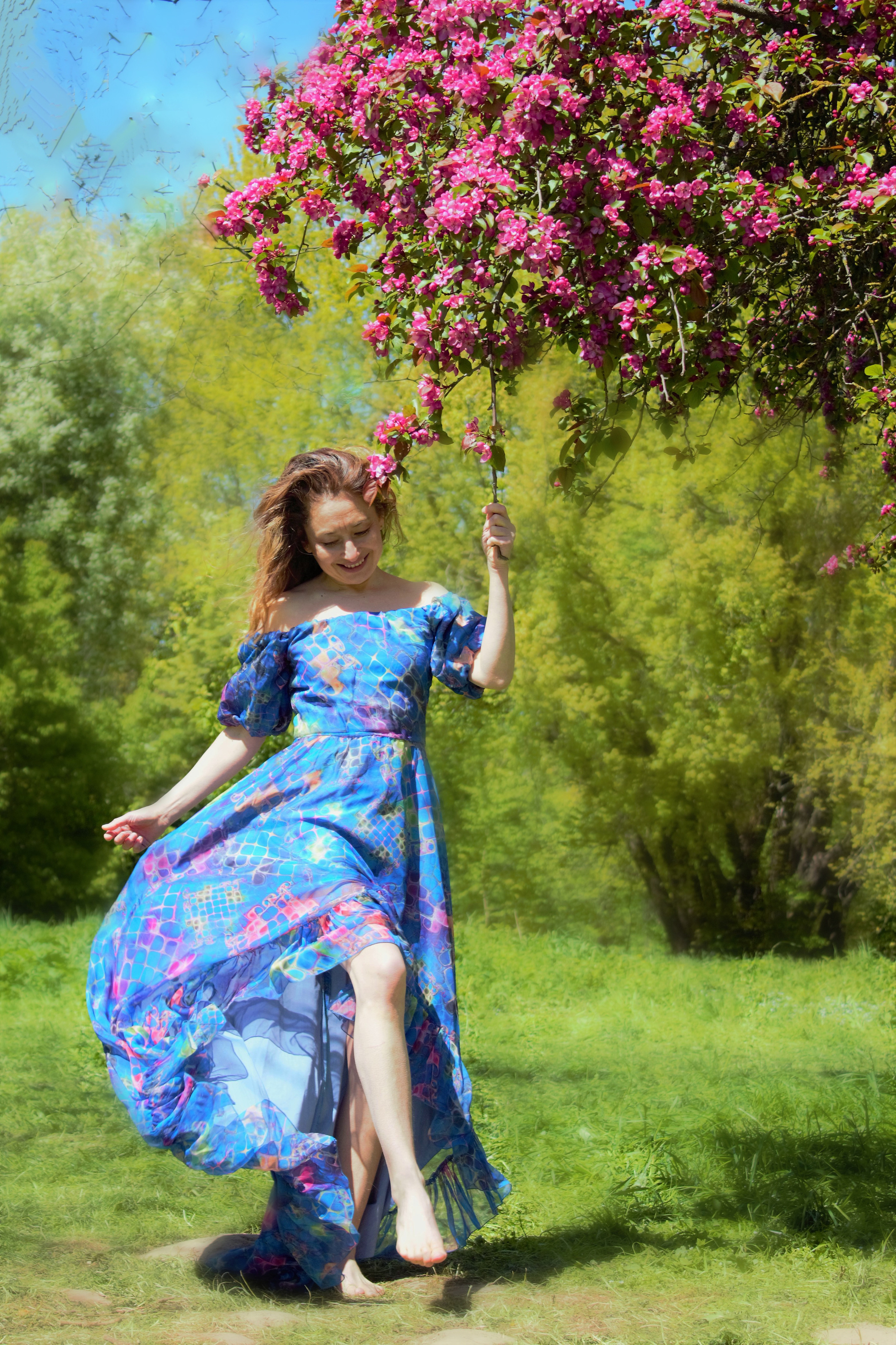 Девушка в парке под цветущей яблоней.