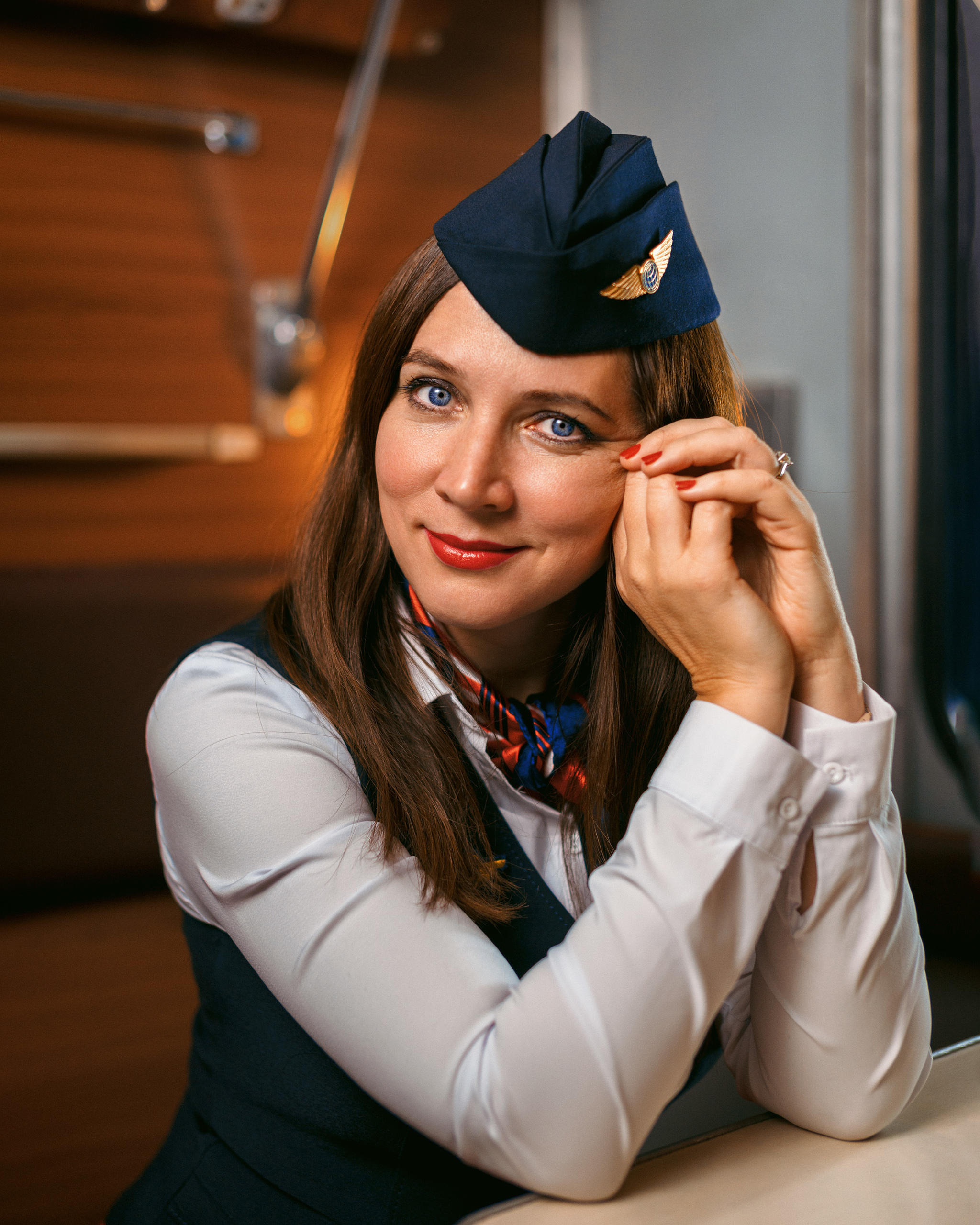 Портрет красивой проводницы в пилотке в вагоне поезда