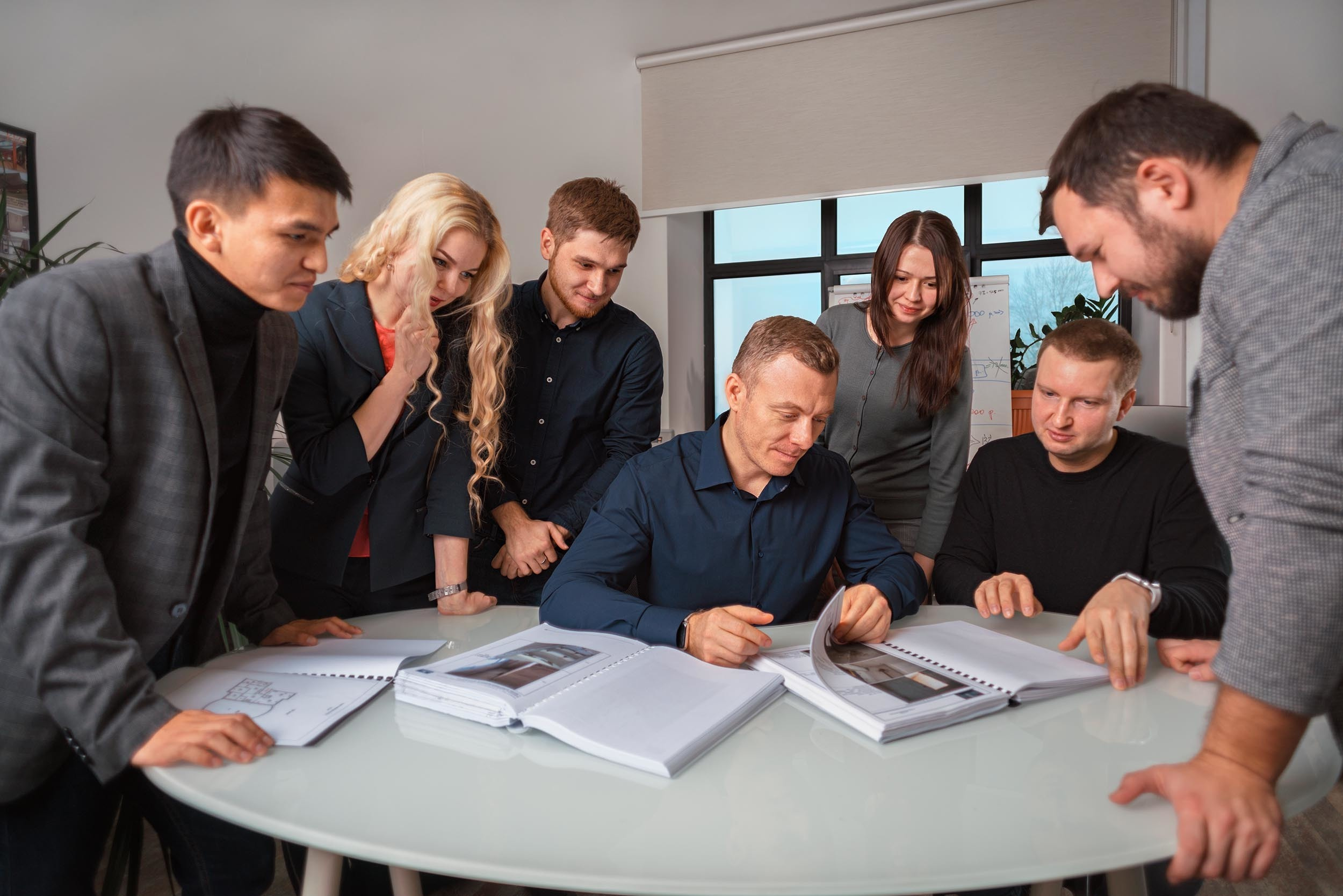 Команда сотрудников работает за столом в офисе