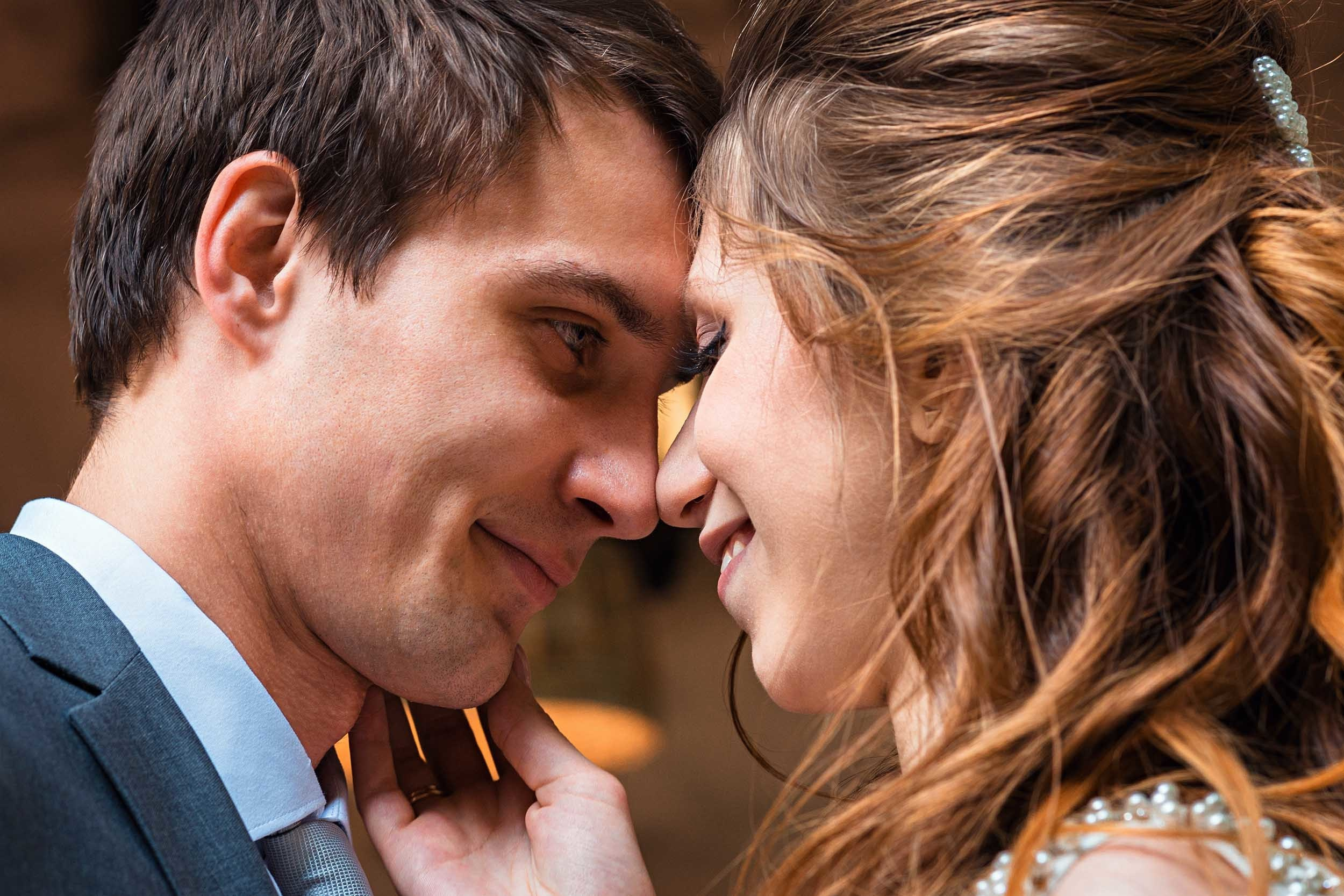 Невеста с женихом соприкасаются лбами и носами