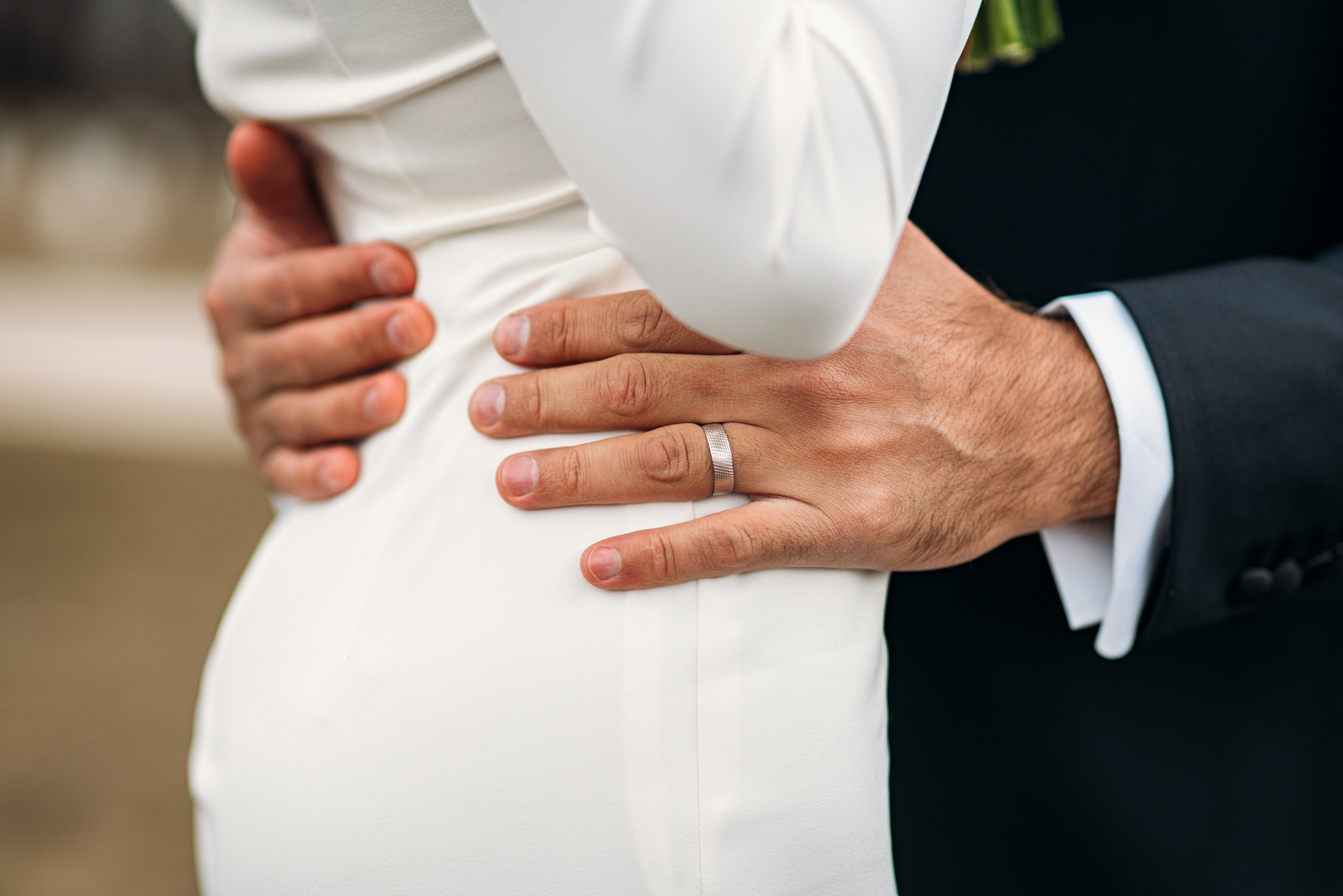 Руки жениха на талии невесты крупным планом