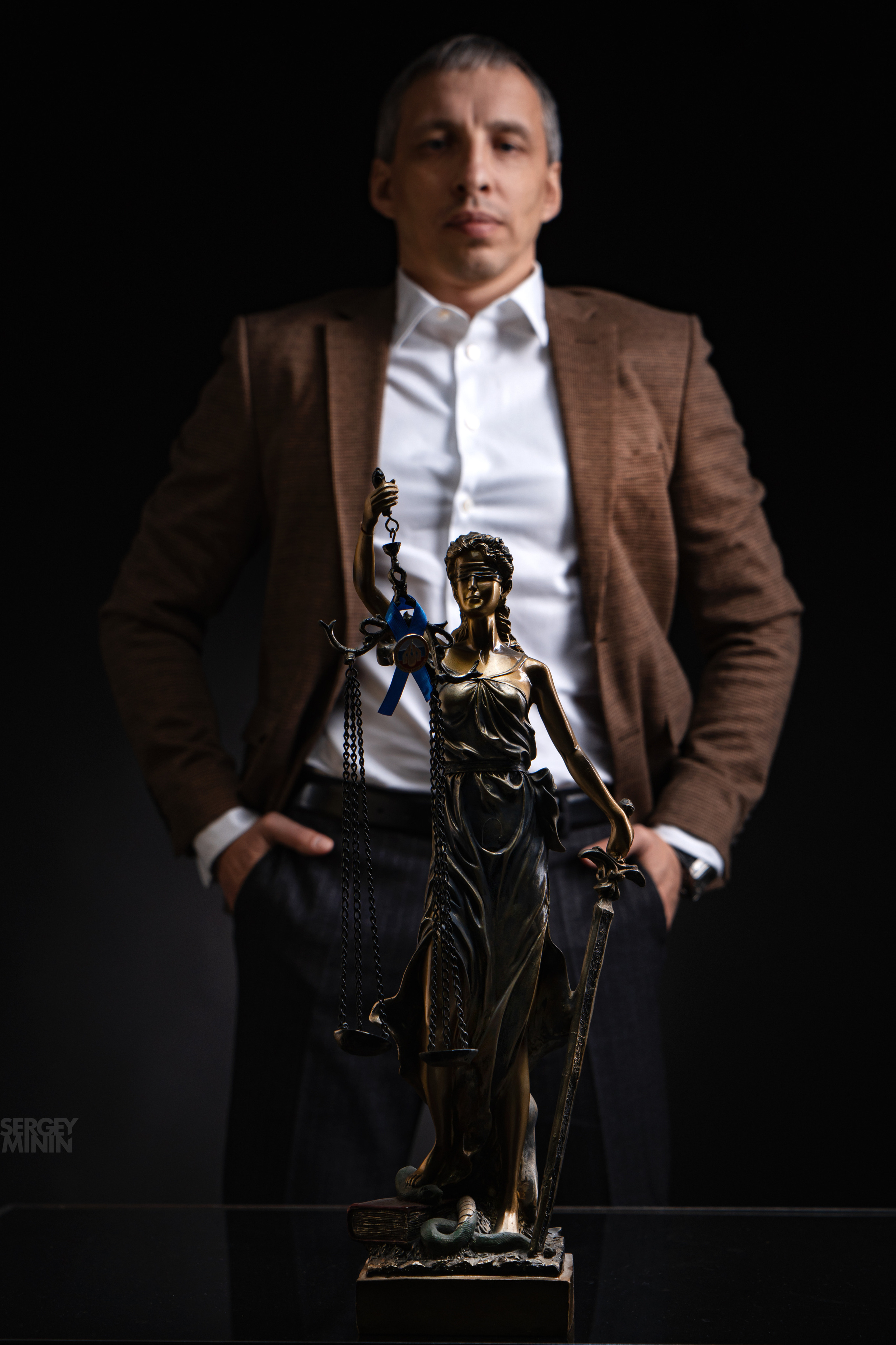 Фотосъемка адвоката в студии рядом со скульптурой Фемиды.