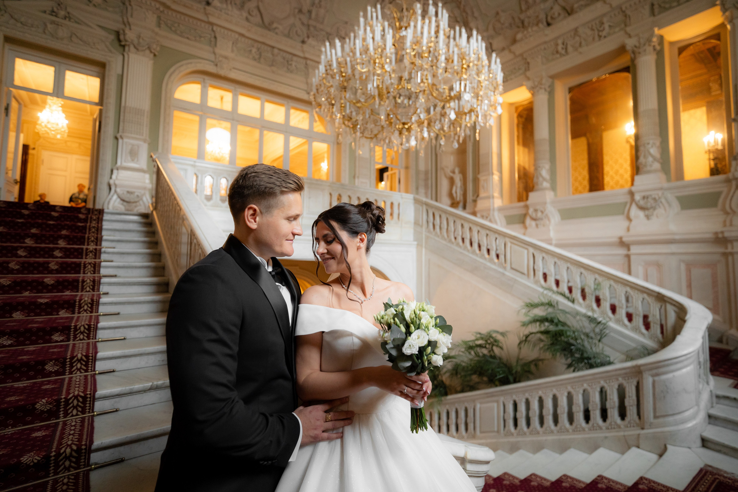 Свадебная фотосессия в Юсуповском дворце. Молодожены стоят на главной лестнице и обнимаются