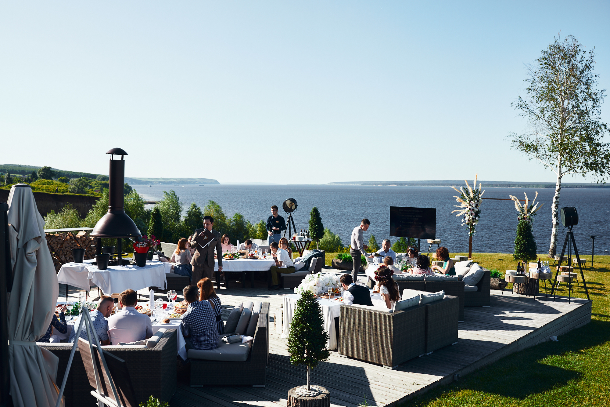 Жених и невеста позируют в красивой локации с деревом и морем