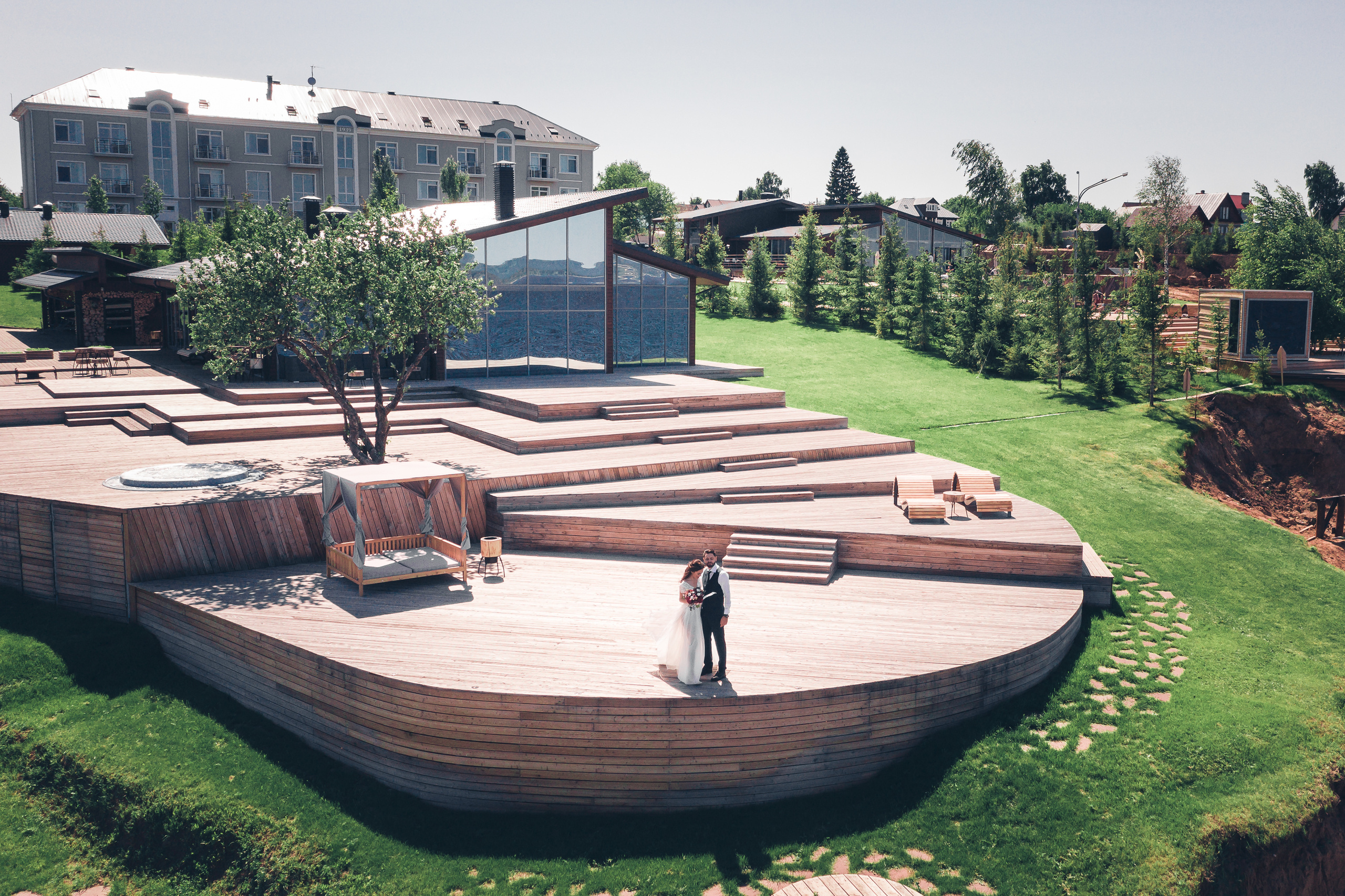 Жених и невеста позируют в красивой локации с деревом и морем 