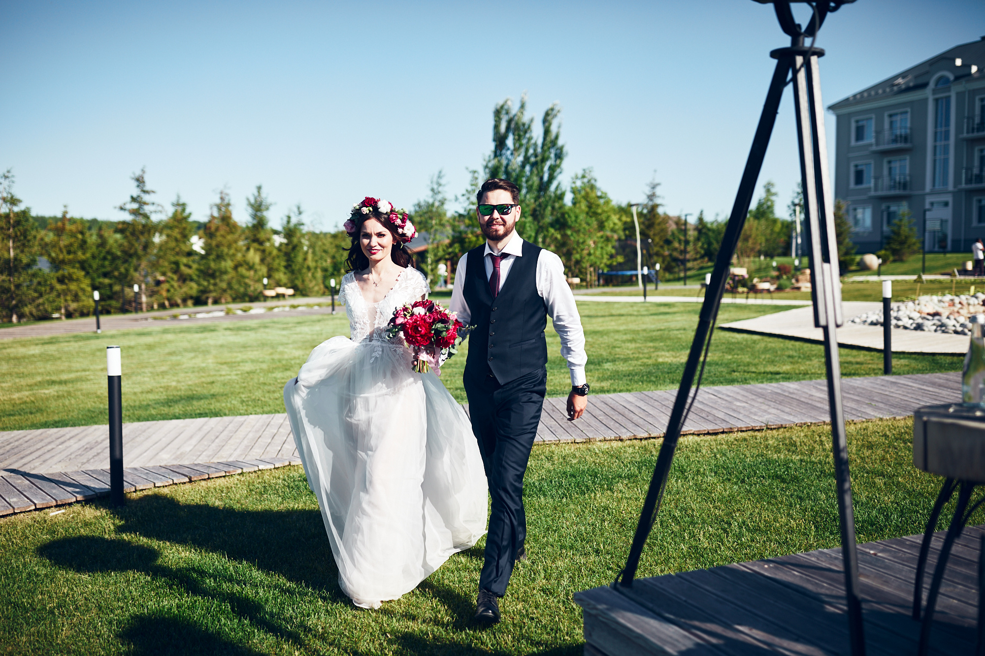 Жених и невеста идут к месту проведения свадебной выездной регистрации