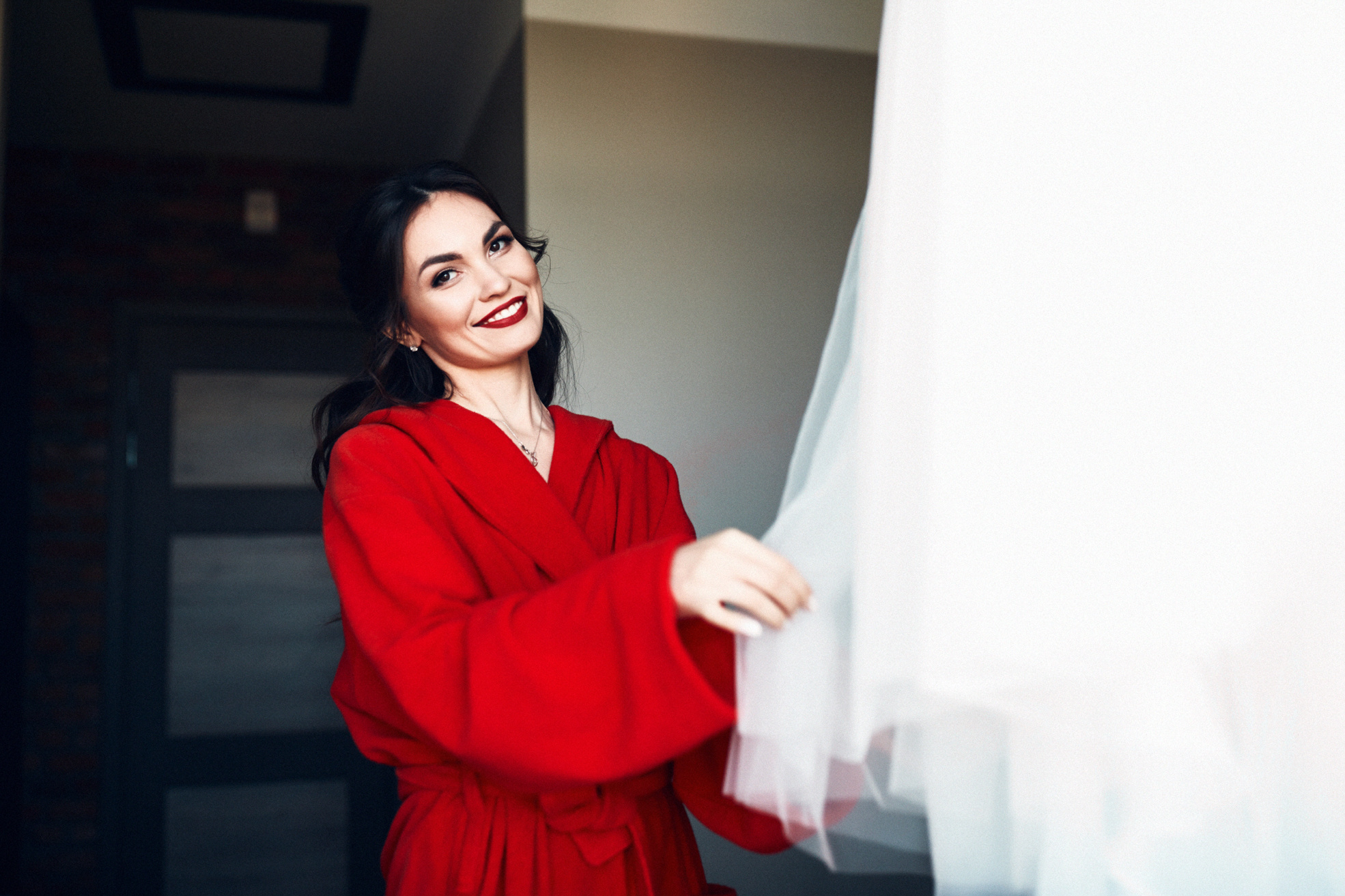 Красивая невеста любуется свадебным платьем