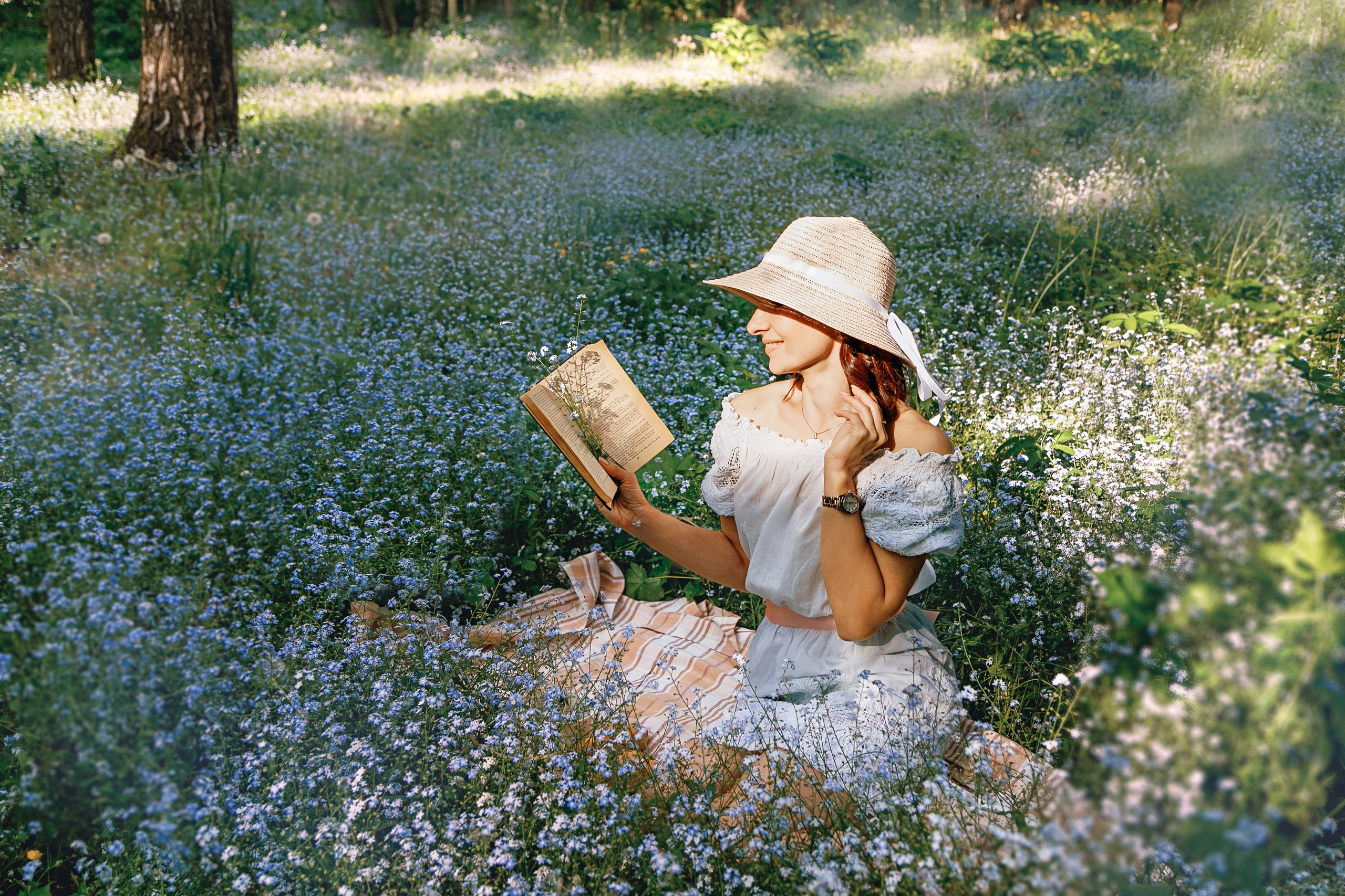 романтическая девушка в шляпке с книгой в голубых незабудках