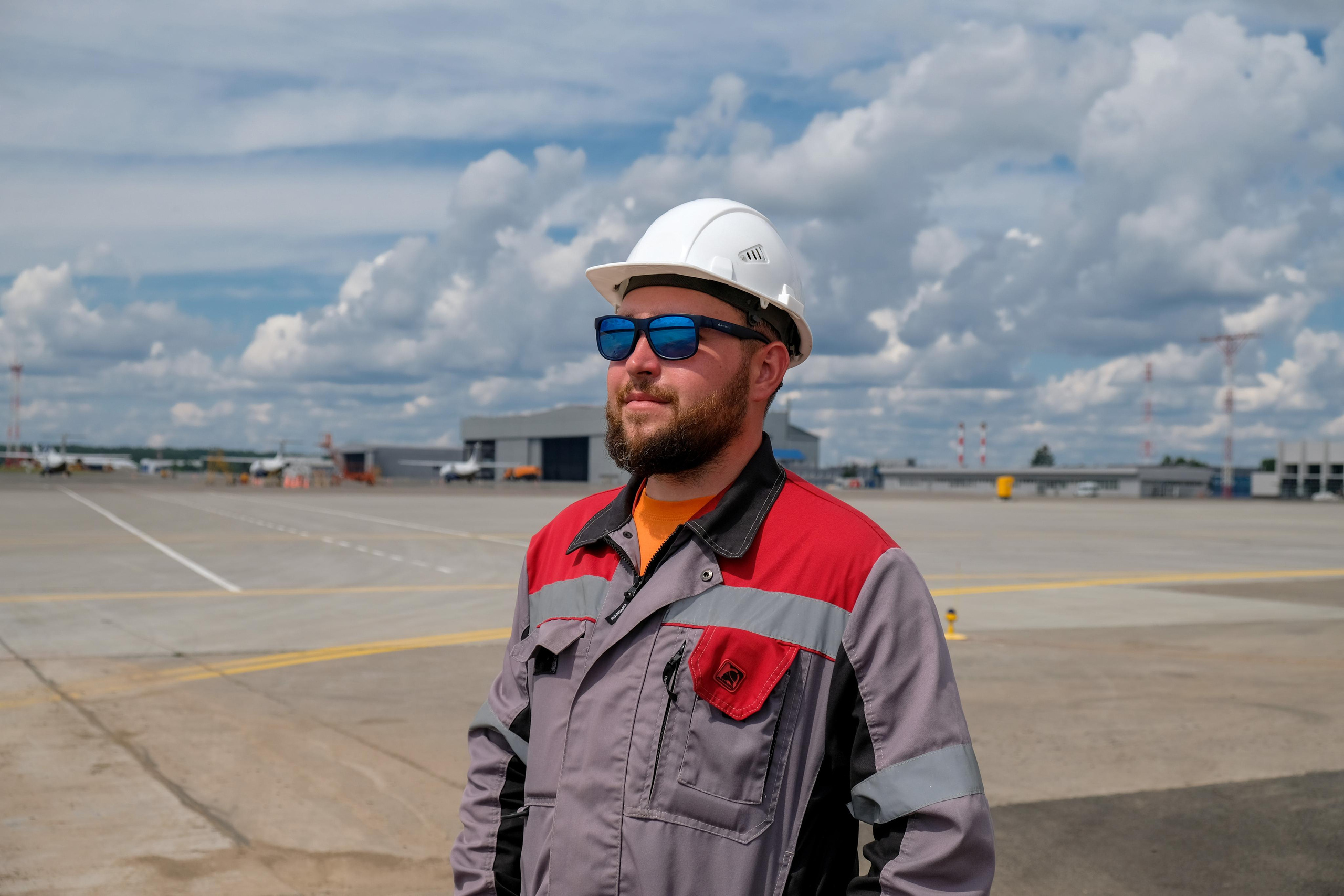 Рабочий в каске и спец одежде на производственном объекте 