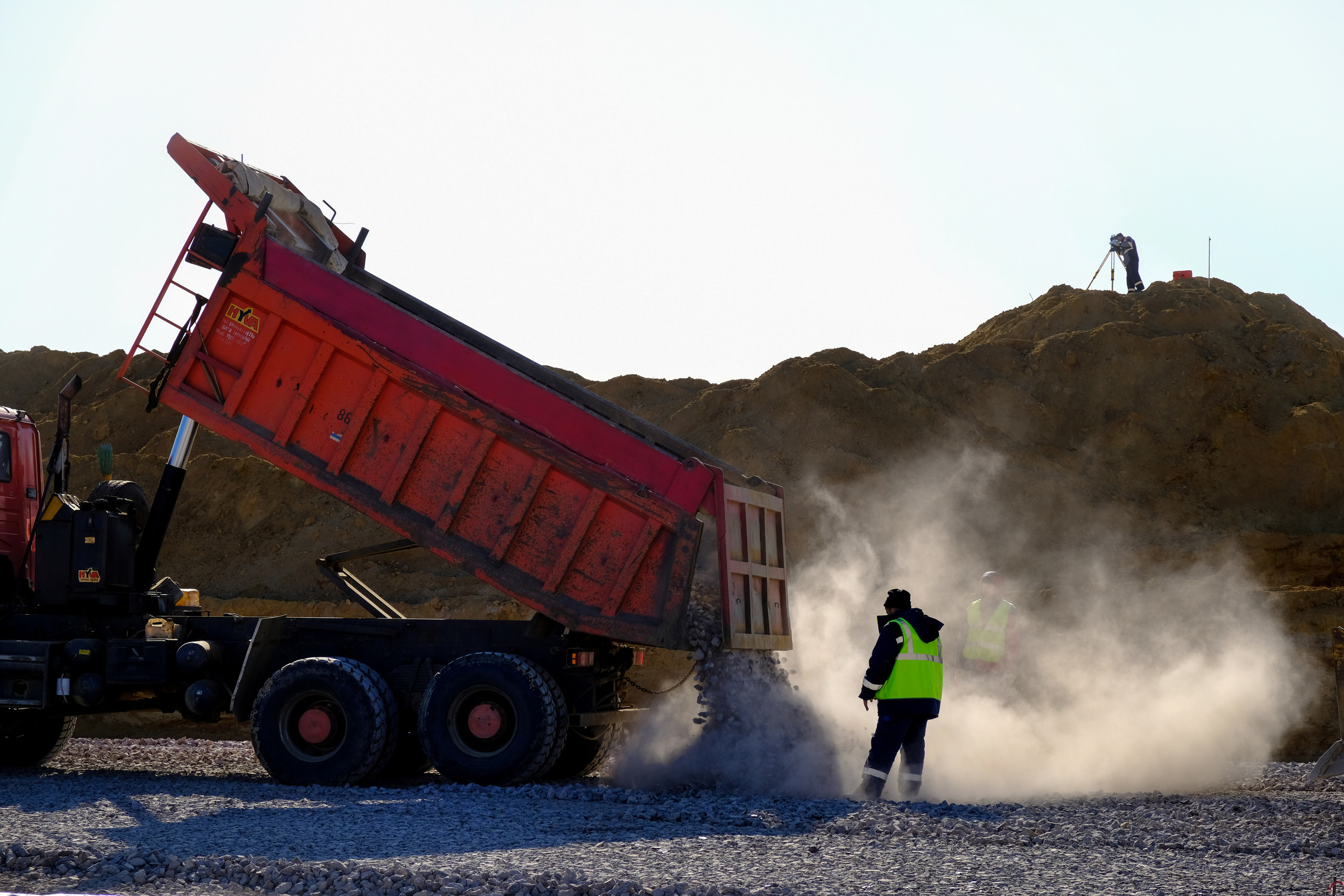 Фотография Грузового  автомобиля высыпающего  из кузова щебень 
