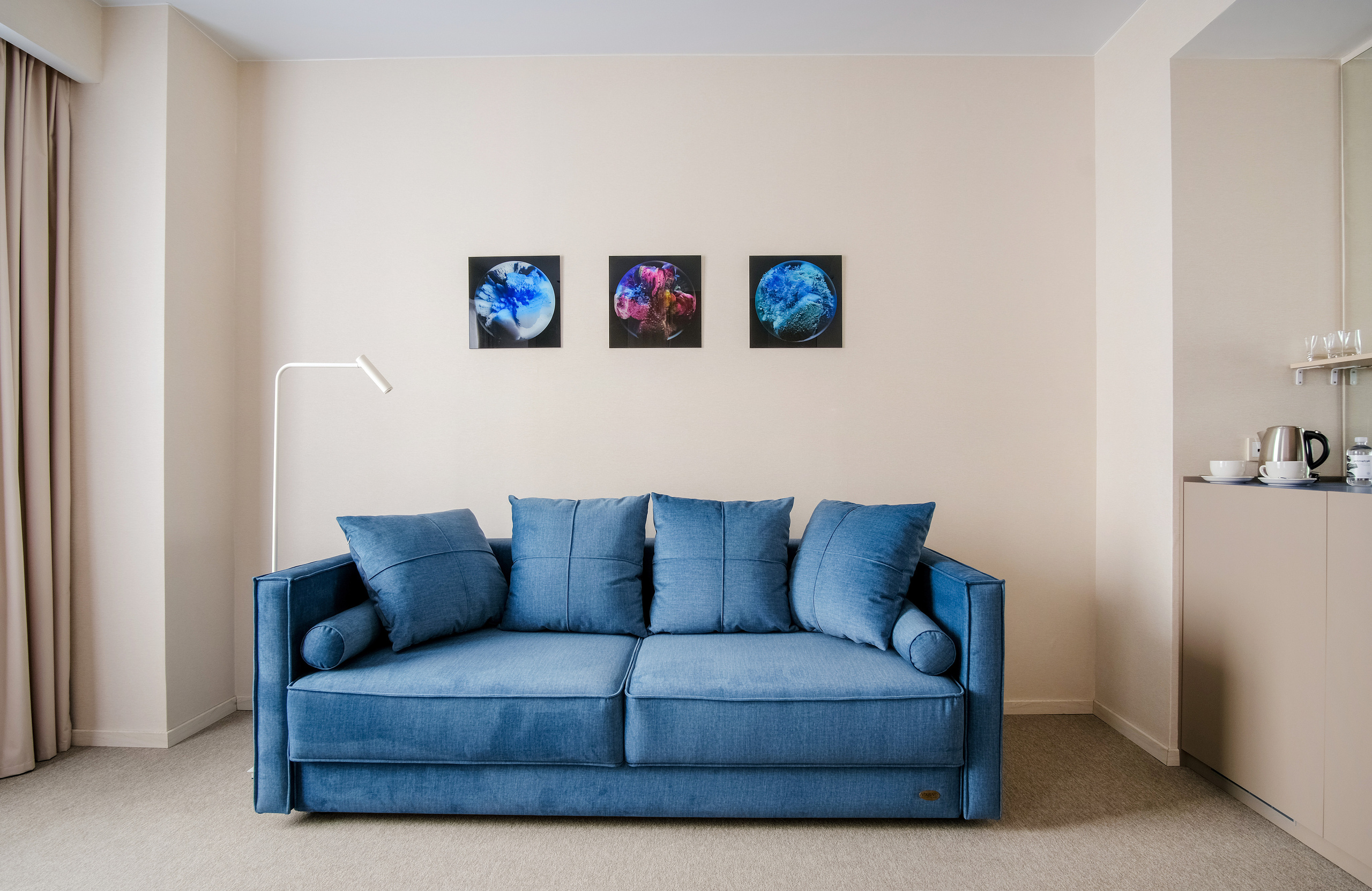 Фотография номера в гостинице с синим диваном 