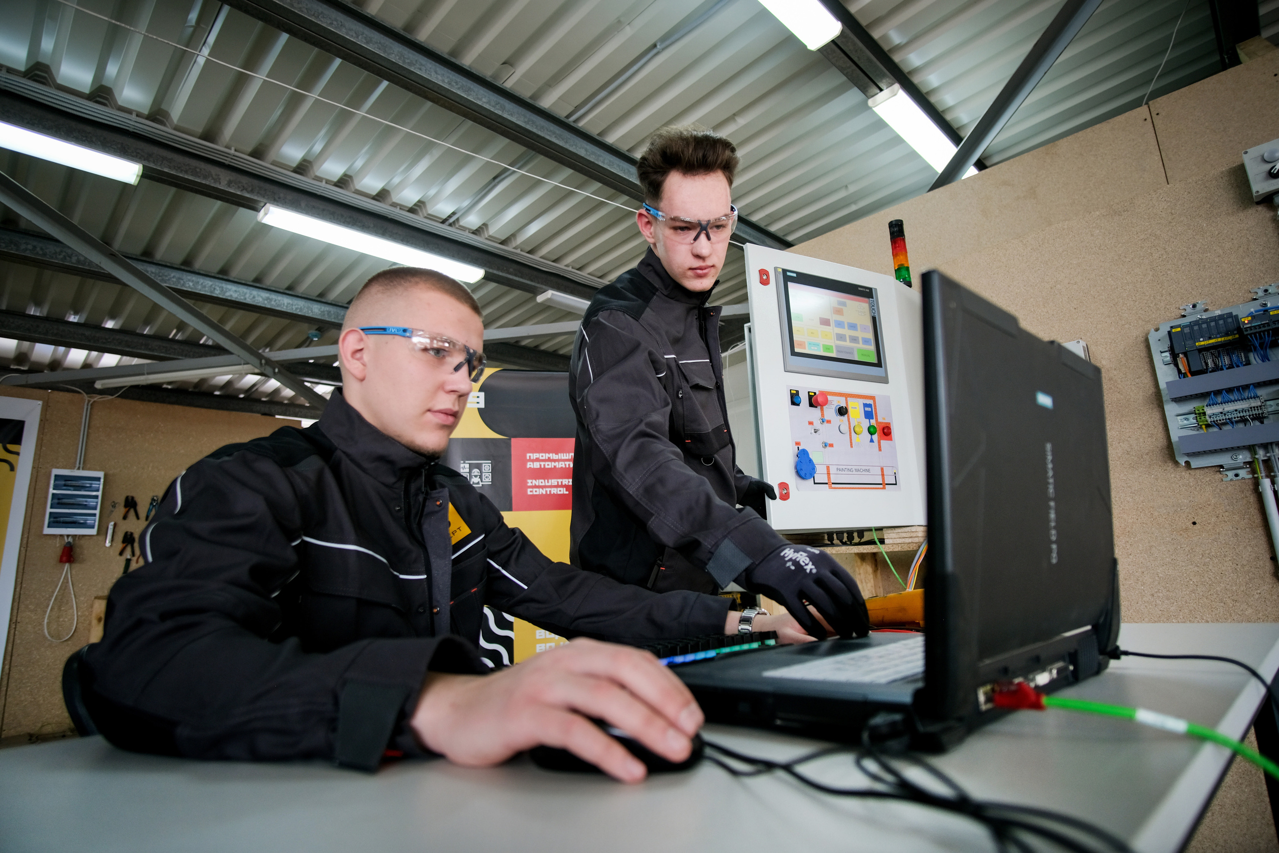 Фотография парней в спецодежде за компьютером моделирования 