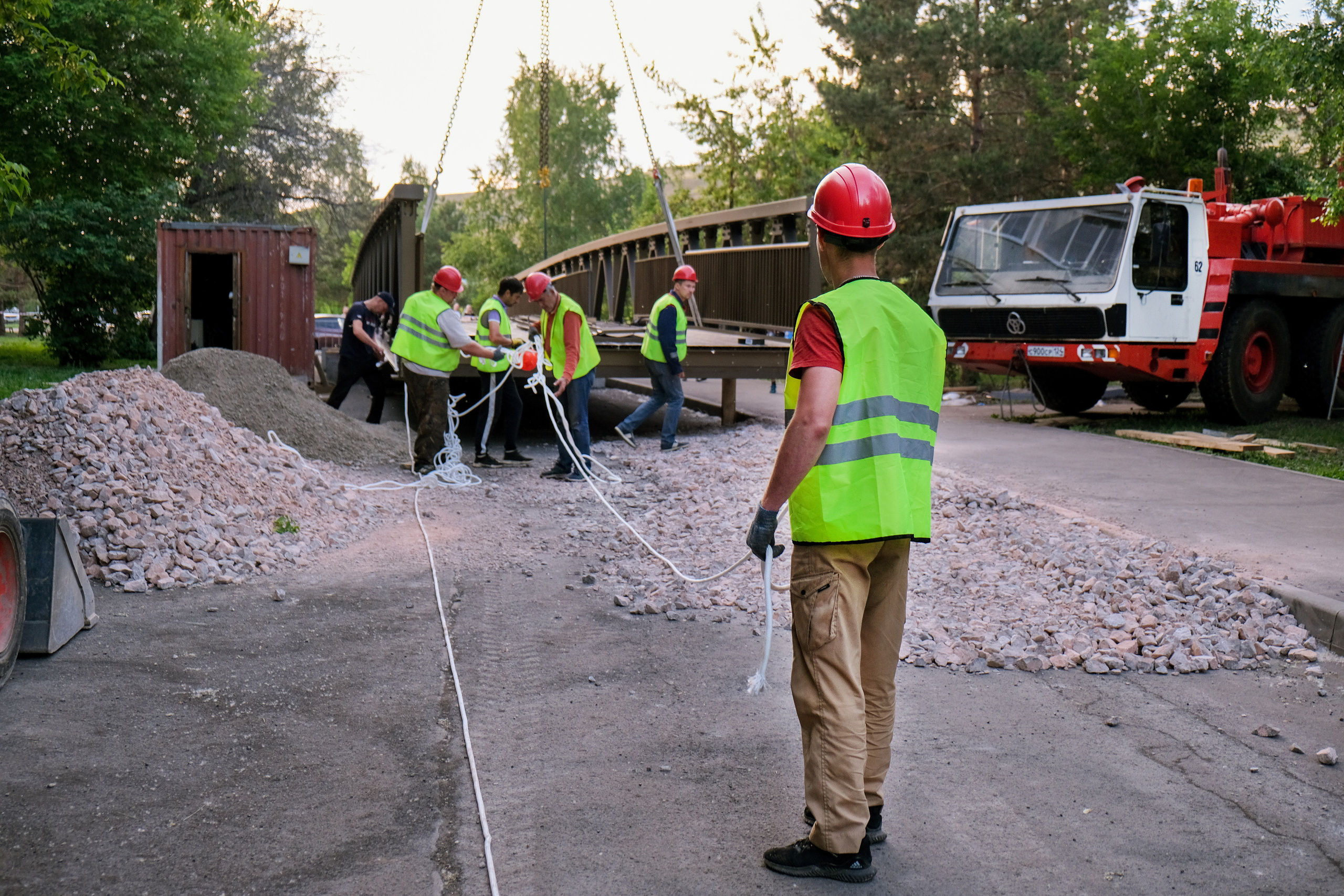 Фотография рабочих готовящих подъем металлической конструкции моста 