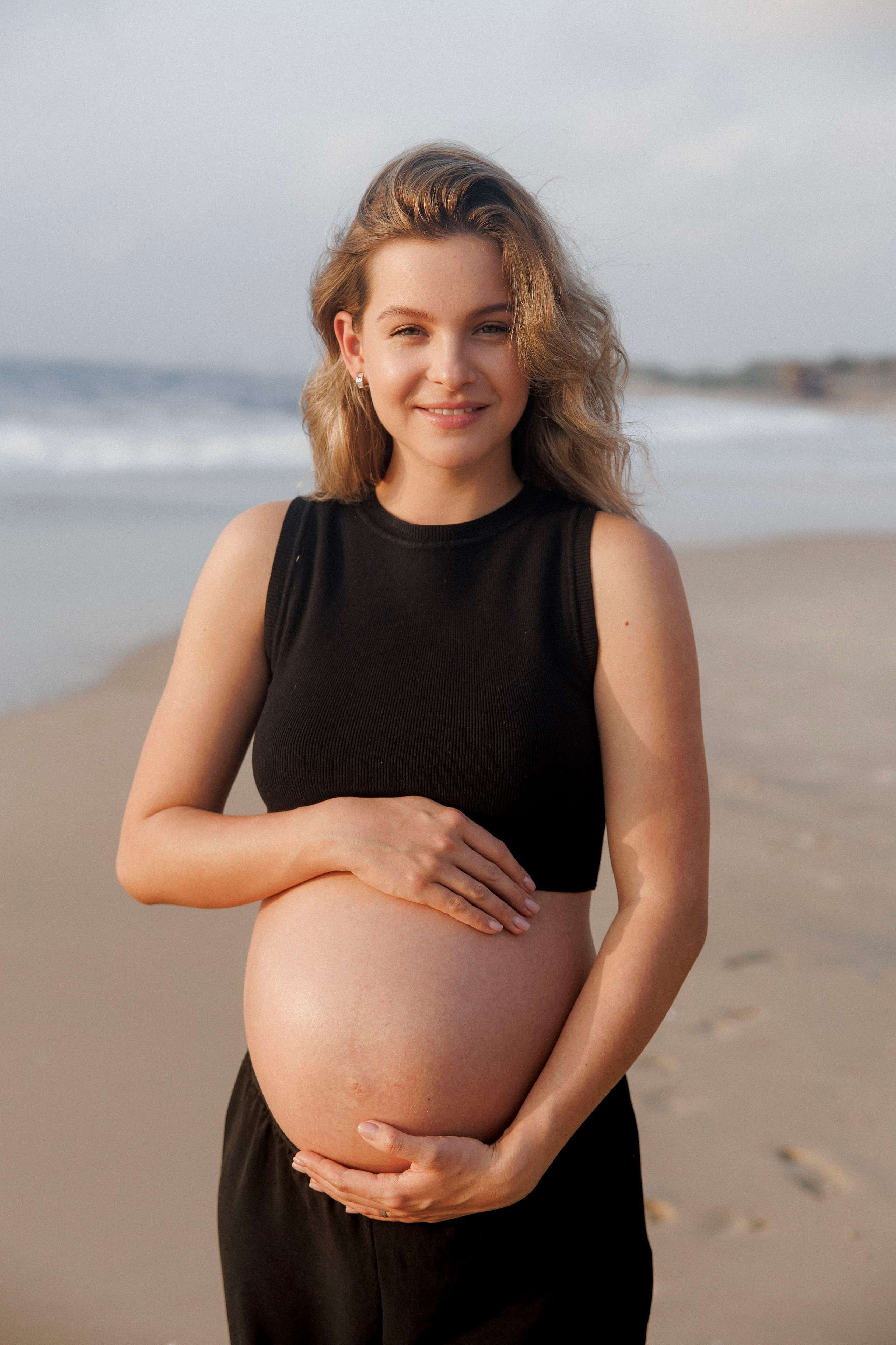 Pregnancy photoshoot near the sea (cloudy weather). Главная