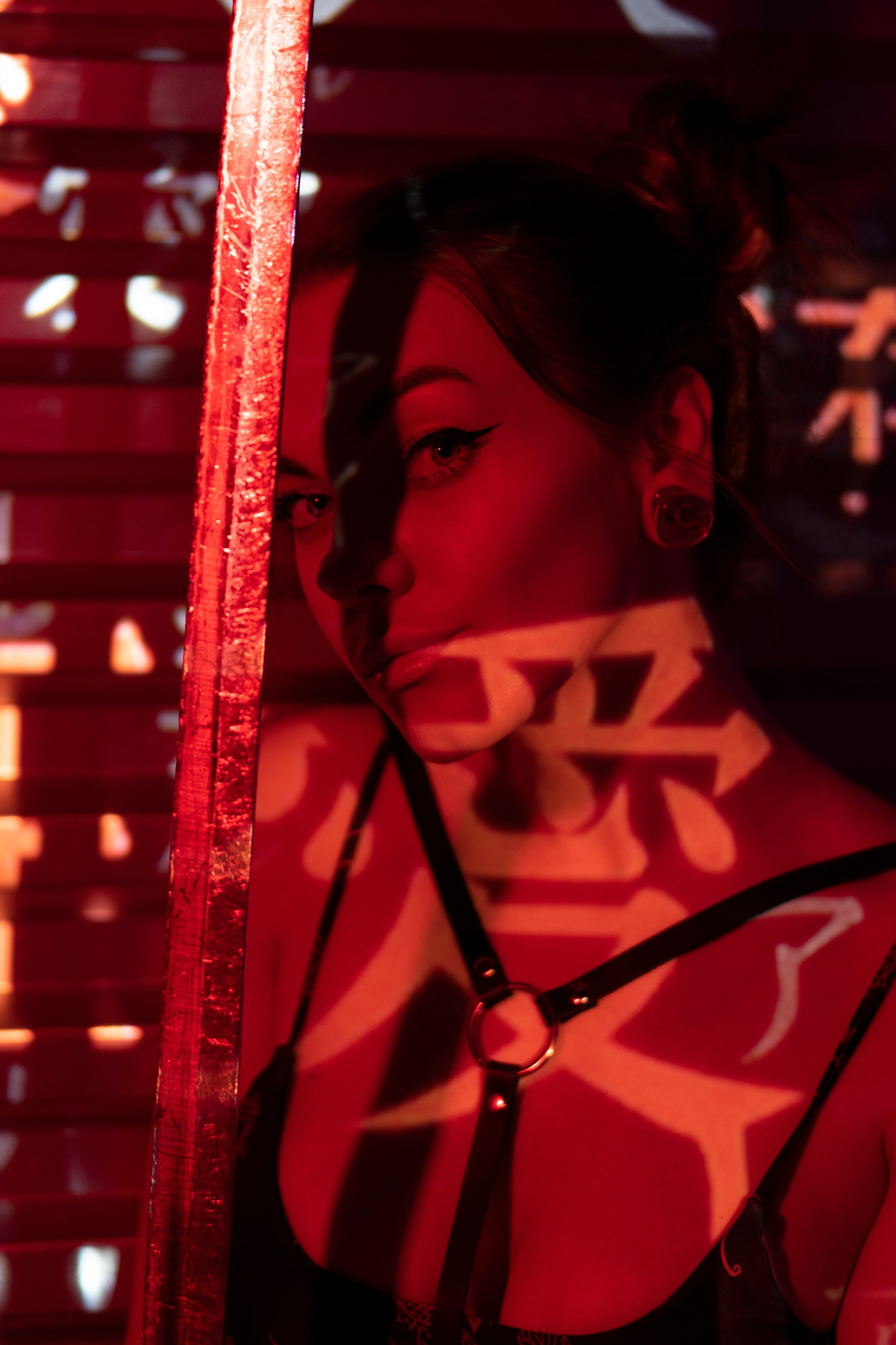 японская гейша в красном свете с саблей и иероглифами