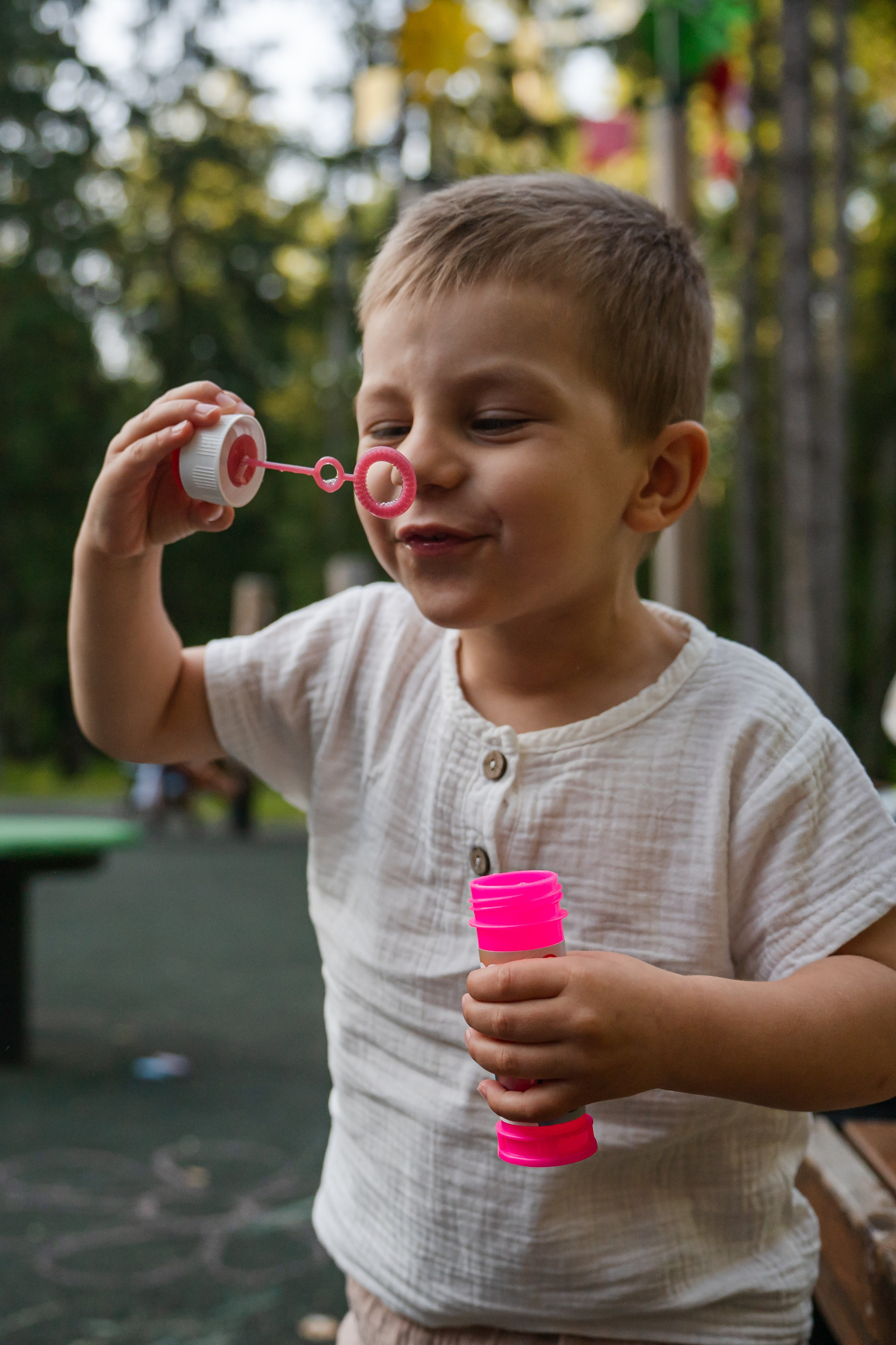 ребенок дует мыльные пузыри. теплая атмосферная фотосессия летом в парке. фотограф Людмила Строкова